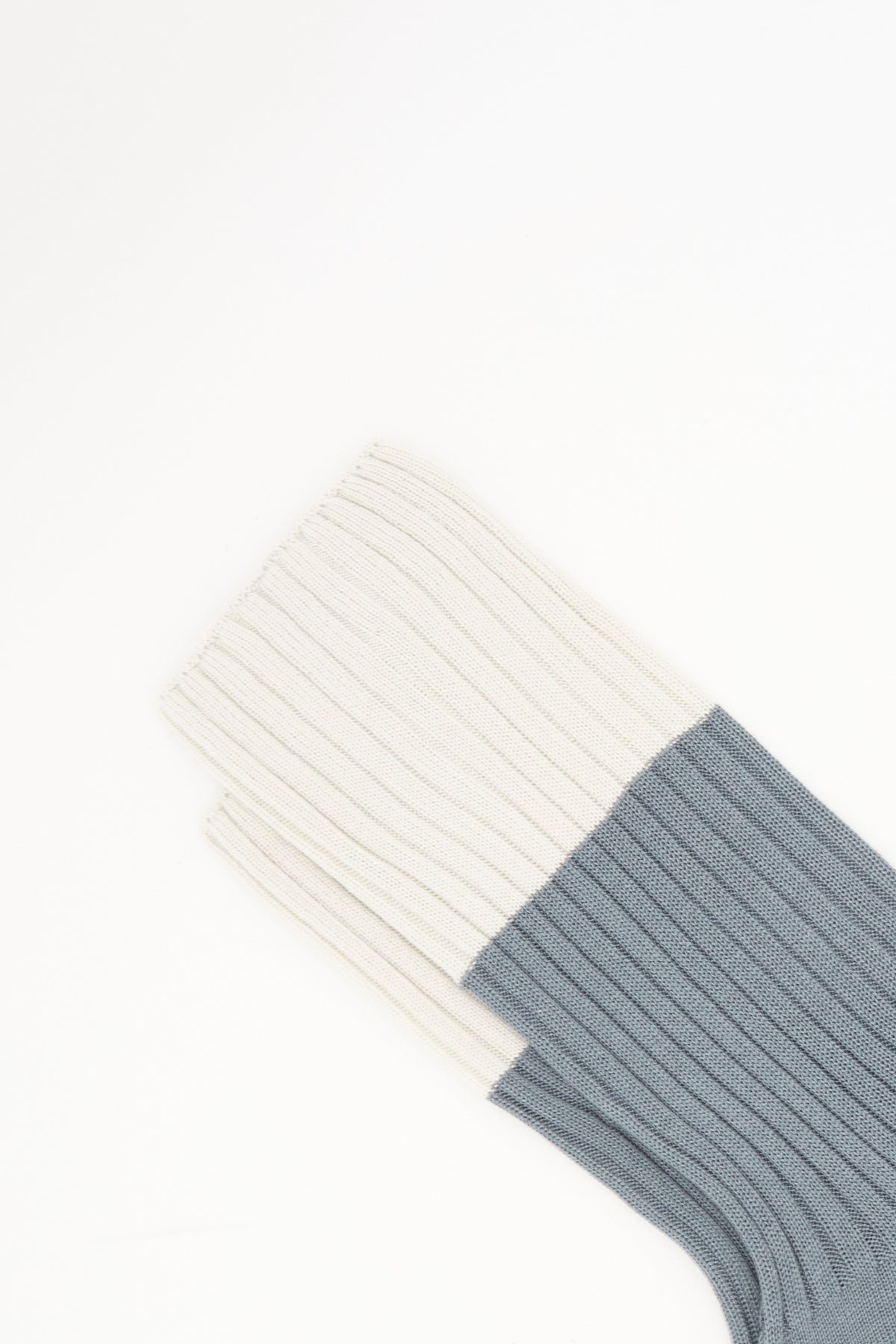 Sofie D’Hoore Bi-Colored Four Rib Socks in Metal, featuring two ribbed, mid-calf socks with cream-colored uppers and grey lower sections.