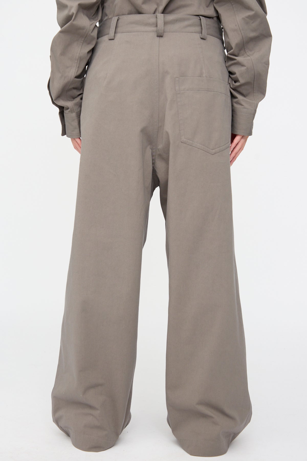 Back view of the Compact Winter Cotton Pasadena Pant in Turtle, featuring relaxed-fit and wide-leg with a single back pocket and a matching long-sleeved shirt tucked in.