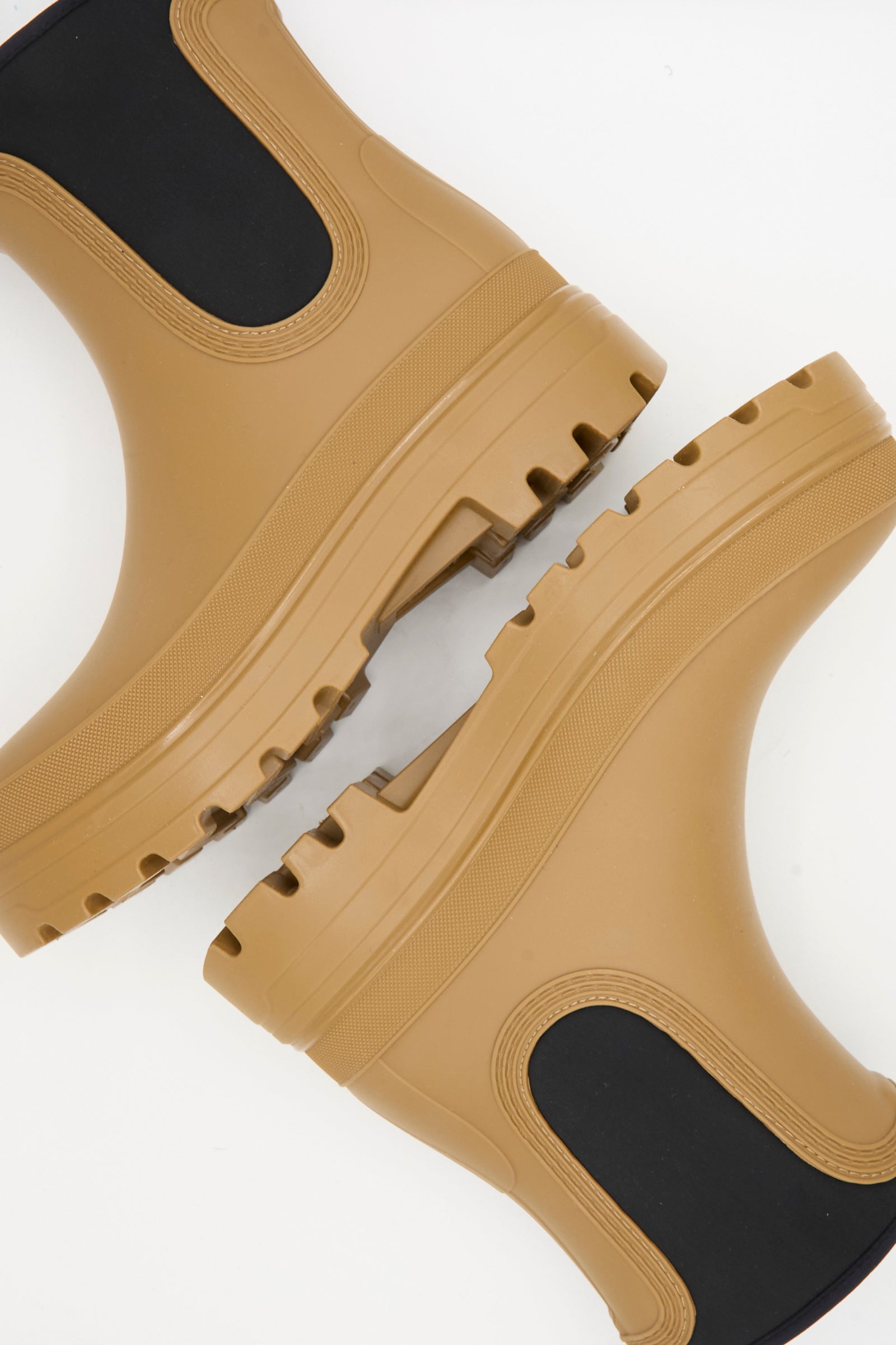 Close-up of Sofie D'Hoore's Falk Rainboot in Caramel, featuring tan rubber, black elastic sides, neoprene opening, and thick textured soles, displayed against a white background.