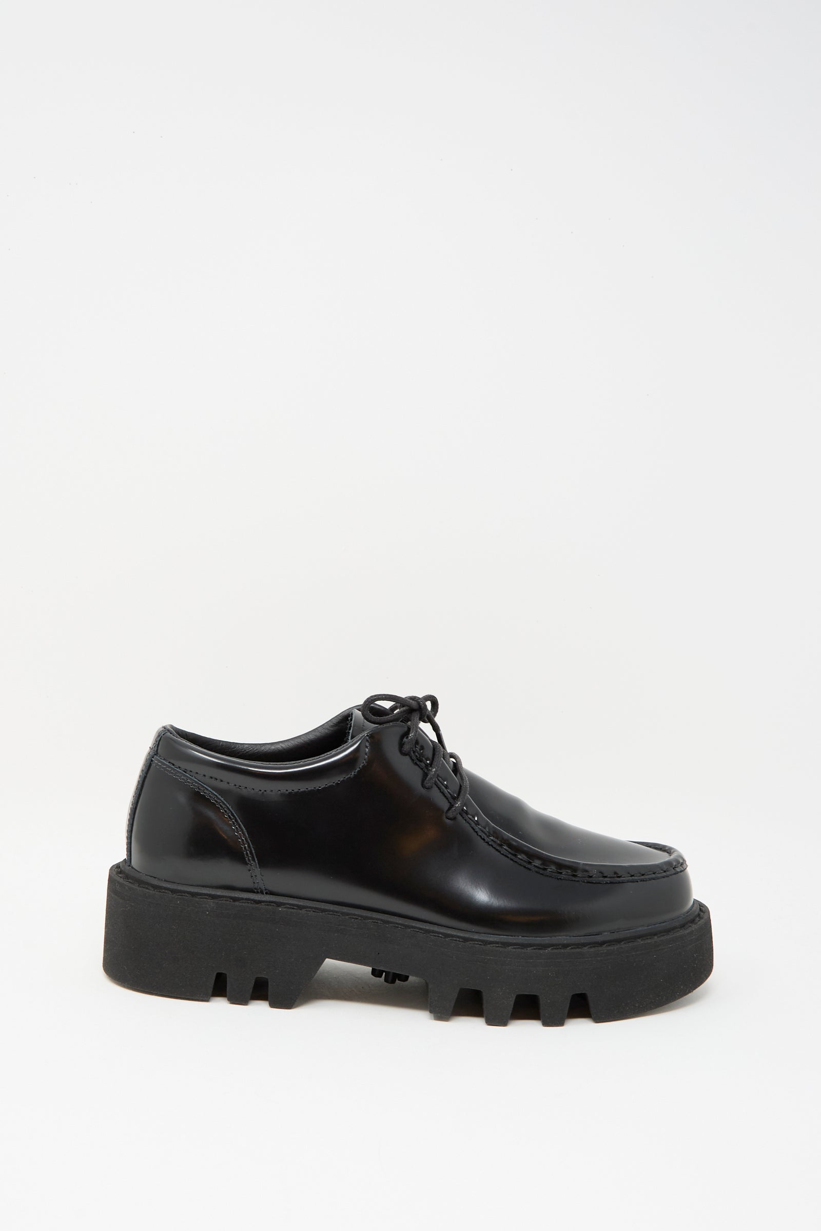 The Sofie D'Hoore Leather Falcone Wallabee Shoe in Black features sleek patent leather and a chunky rubber sole, shown as a single shoe against a plain white background.