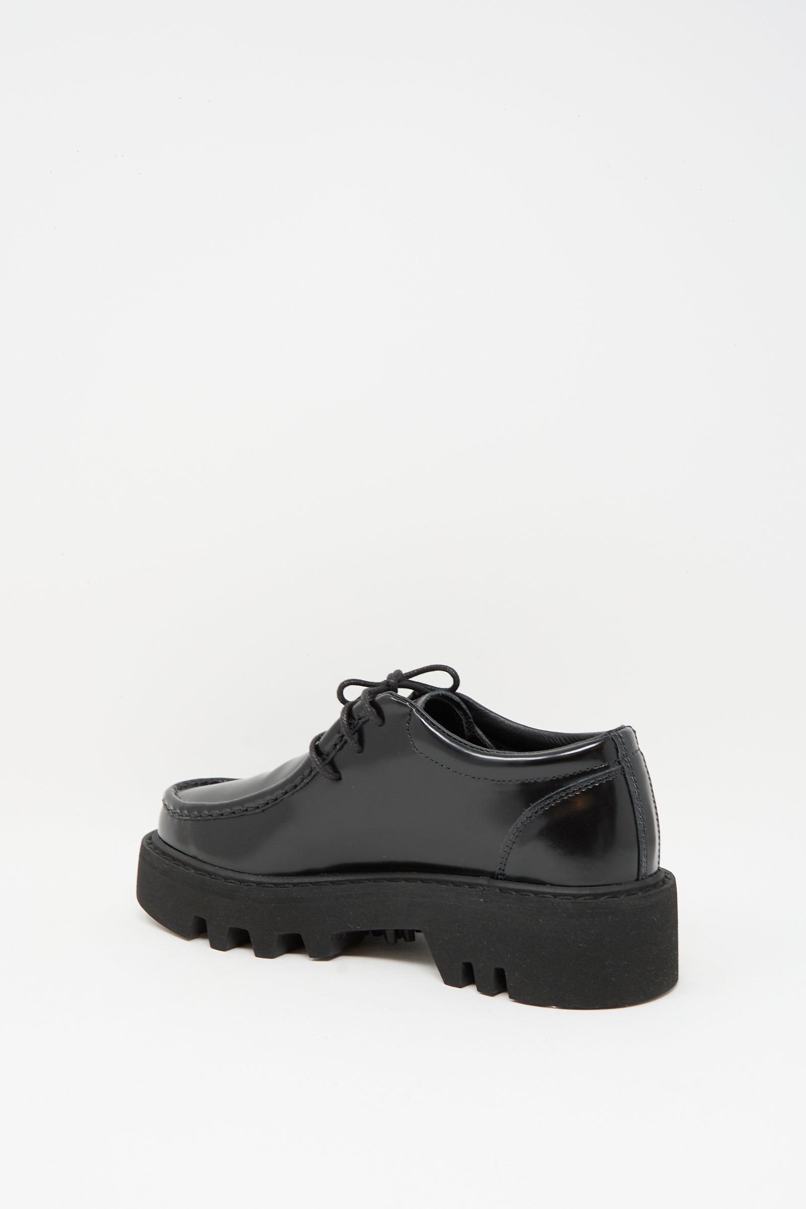 The Sofie D'Hoore Leather Falcone Wallabee Shoe in Black features sleek patent leather, lace-up design, chunky rubber sole, and subtle wallabee style, shown from the back against a plain white background.