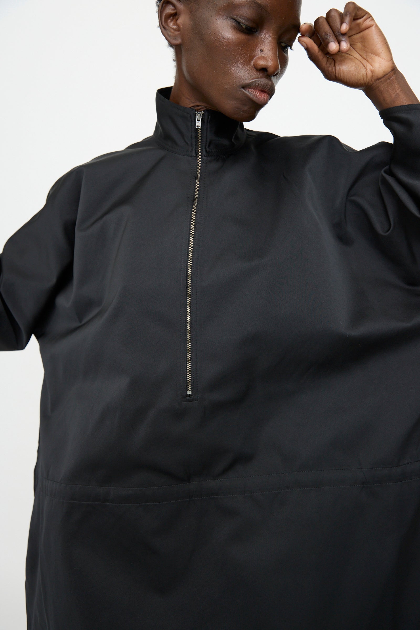 Model wearing the Sofie D'Hoore Satin Dolci Dress in Black, standing against a plain background with one arm raised.