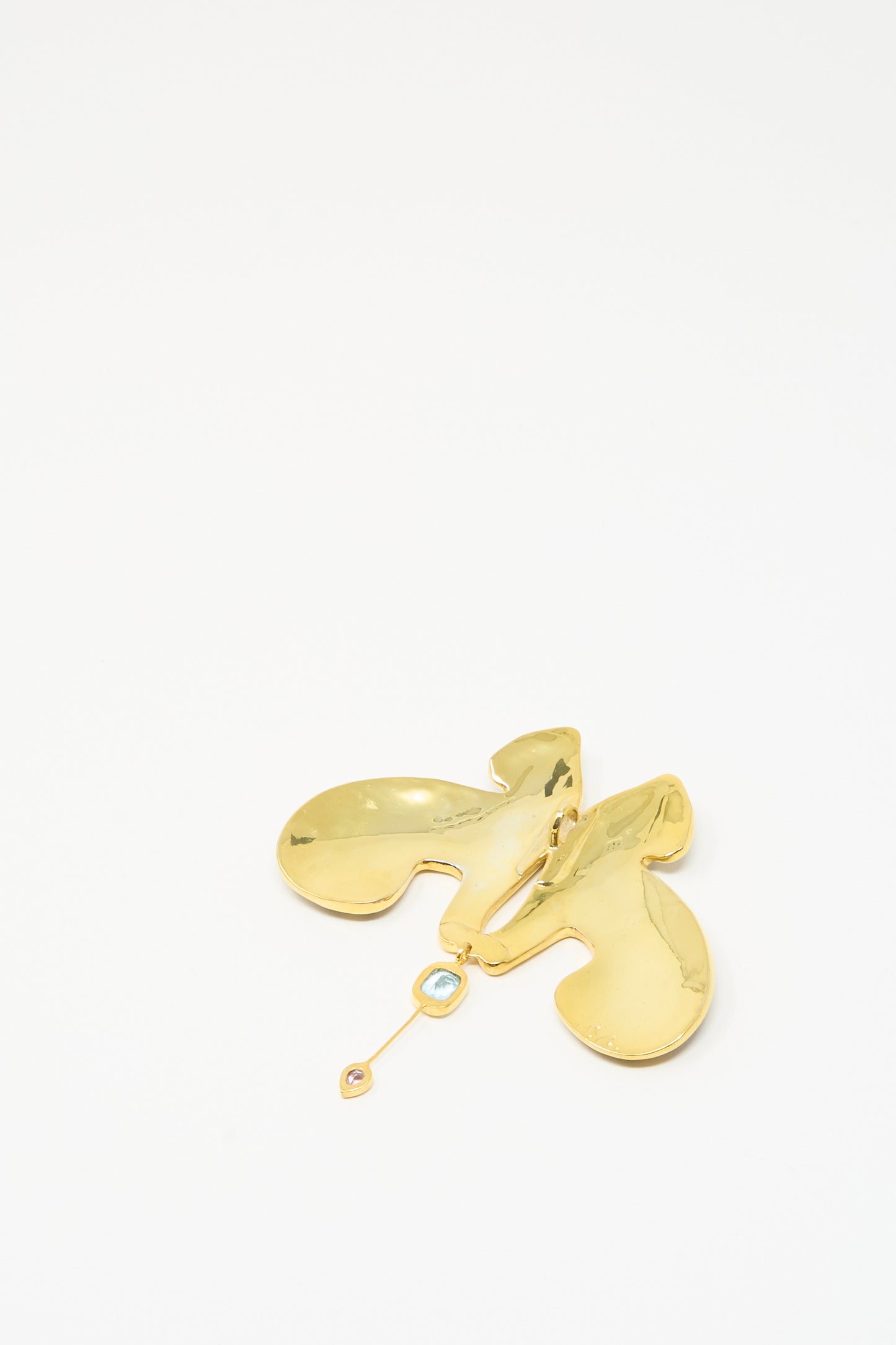 The Sofio Gongli Tiger Pendant is a 14K gold plated abstract brooch with two curved shapes and a dangling element featuring a small round gem, shown on a plain white background.