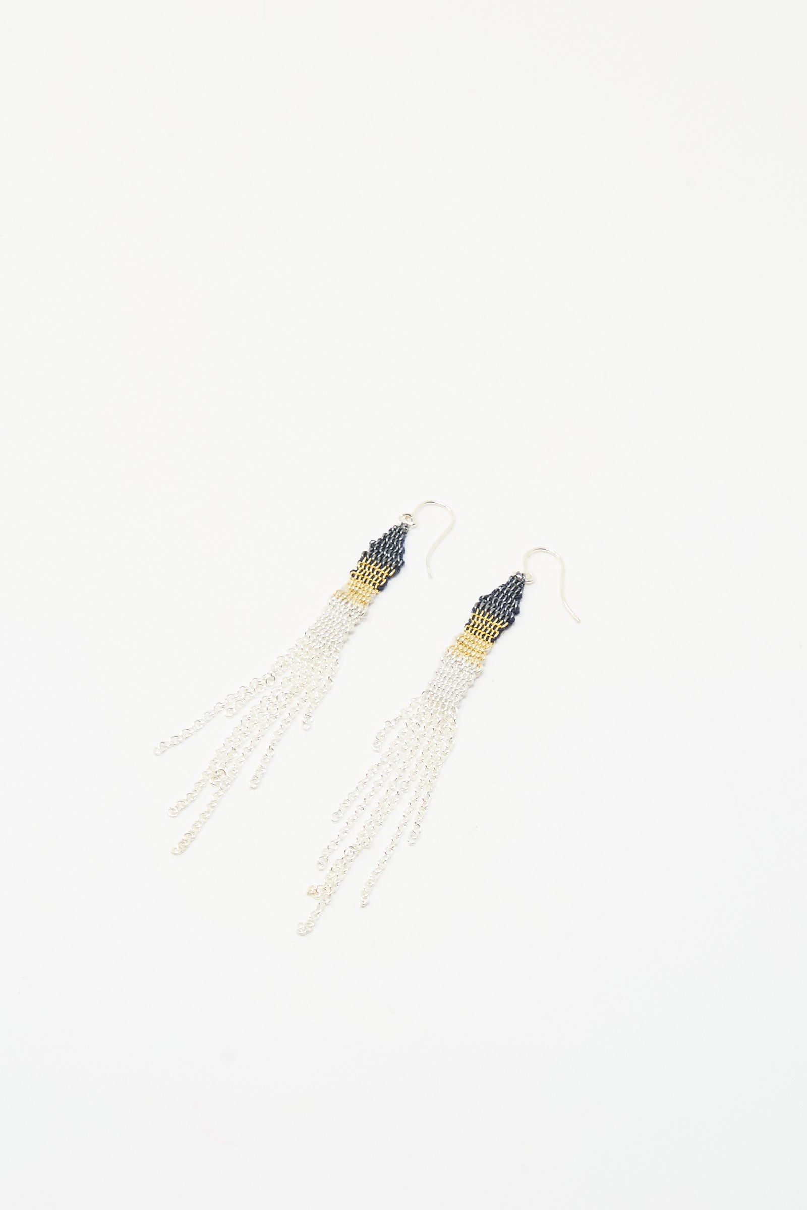 The Silver and Silk Woven Earrings by Stephanie Schneider feature dark beaded tops, gold accents, and long sterling silver chains, shown on a white background.