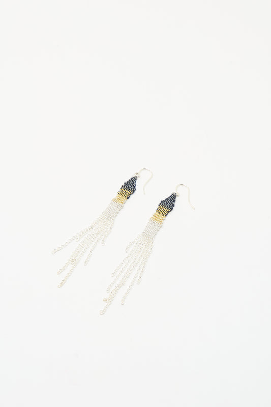 The Silver and Silk Woven Earrings by Stephanie Schneider feature dark beaded tops, gold accents, and long sterling silver chains, shown on a white background.