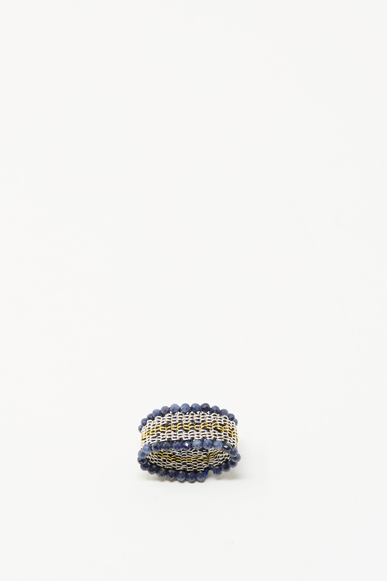 The Stephanie Schneider Silver, Gold Plated, and Silk Woven Ring with Blue Sapphires is displayed on a plain white background.