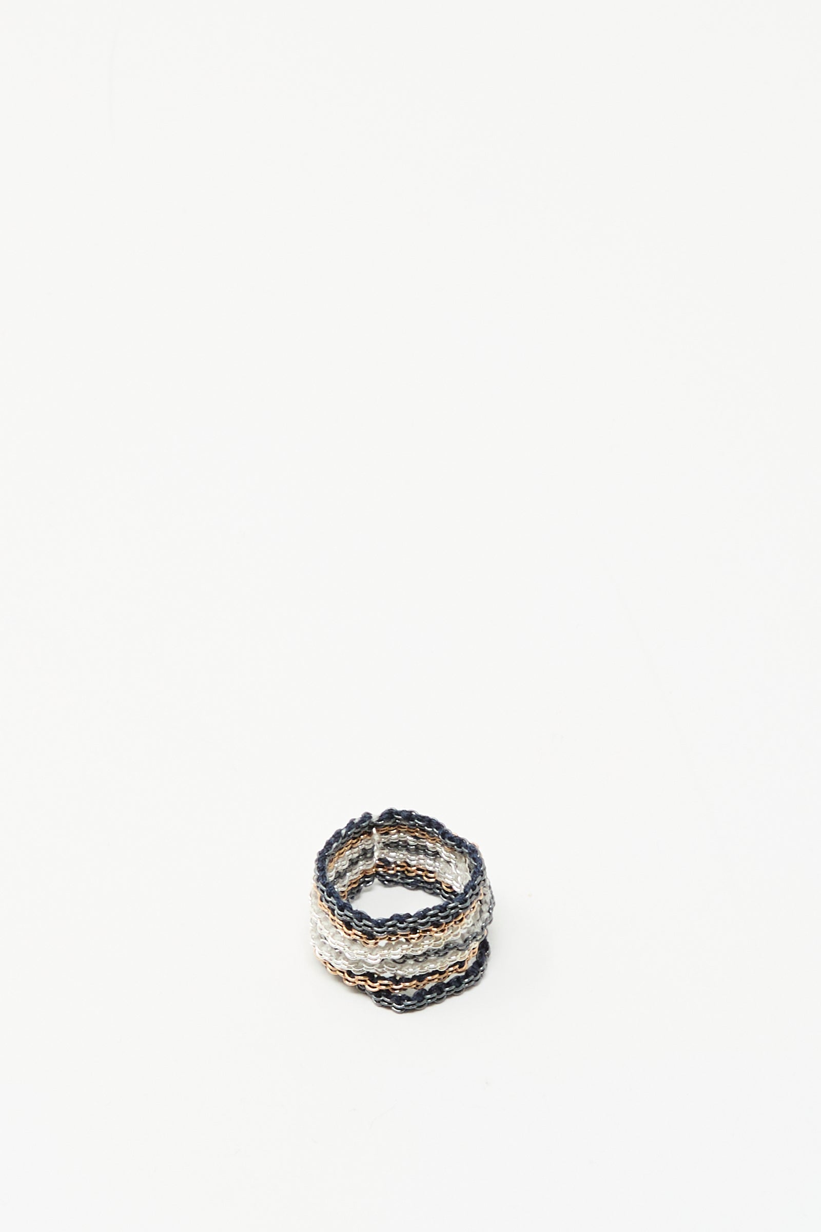The Stephanie Schneider Silver, Rose Gold Plated and Silk Woven Ring features intertwined silver, rose gold-plated metal, and silk on a white background.