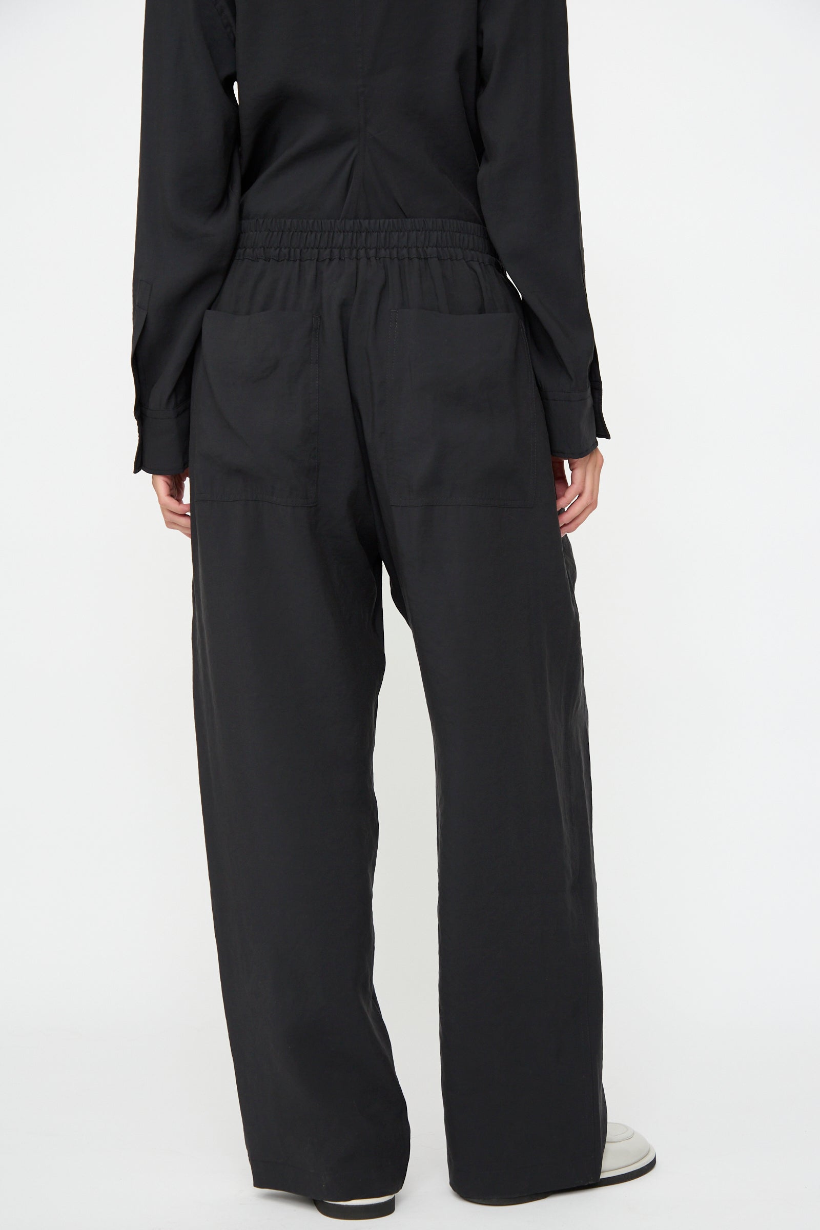Person wearing Studio Nicholson Capel Pant in Darkest Navy and a black long-sleeve top, shown from the back against a plain light background.