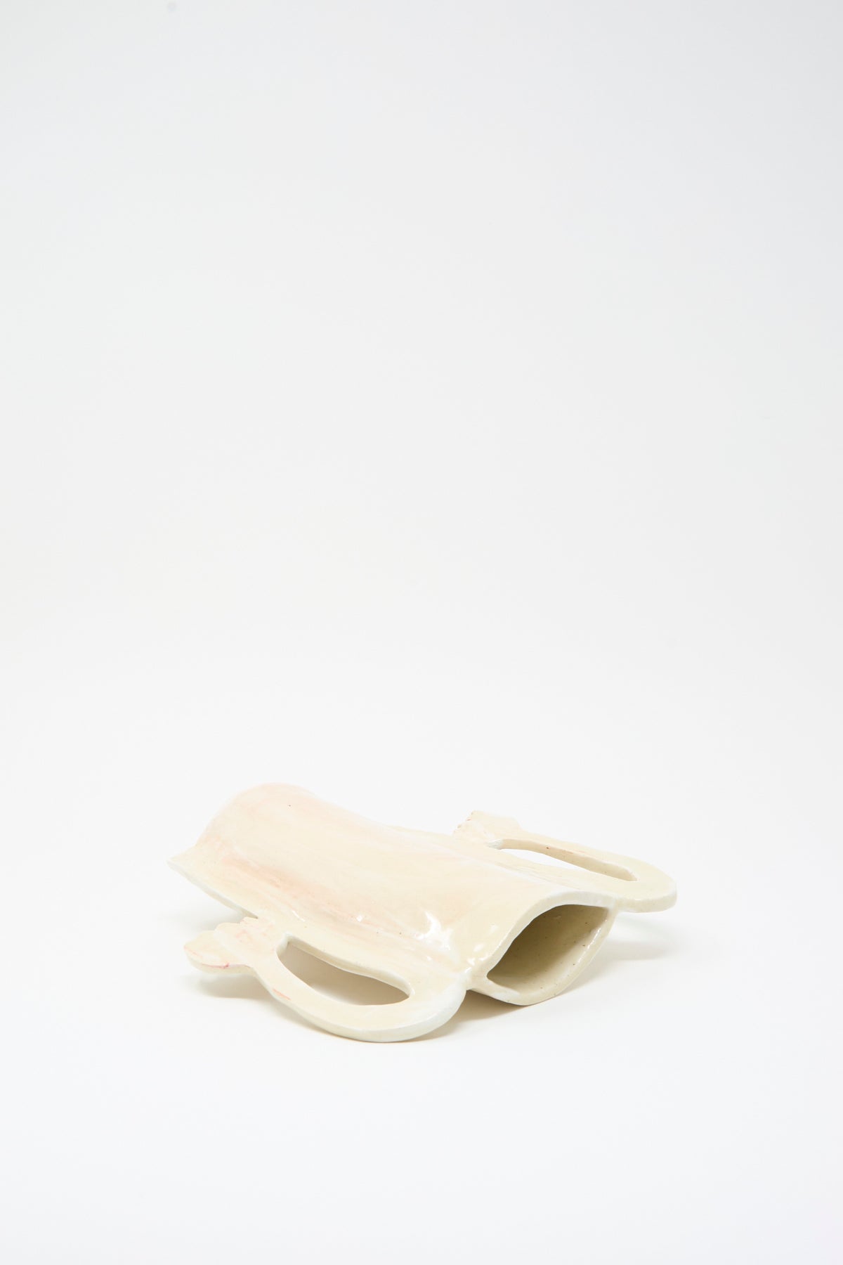 Handmade cream-colored Two Fritillaria in the Morning Vase with two handles, lying on its side.