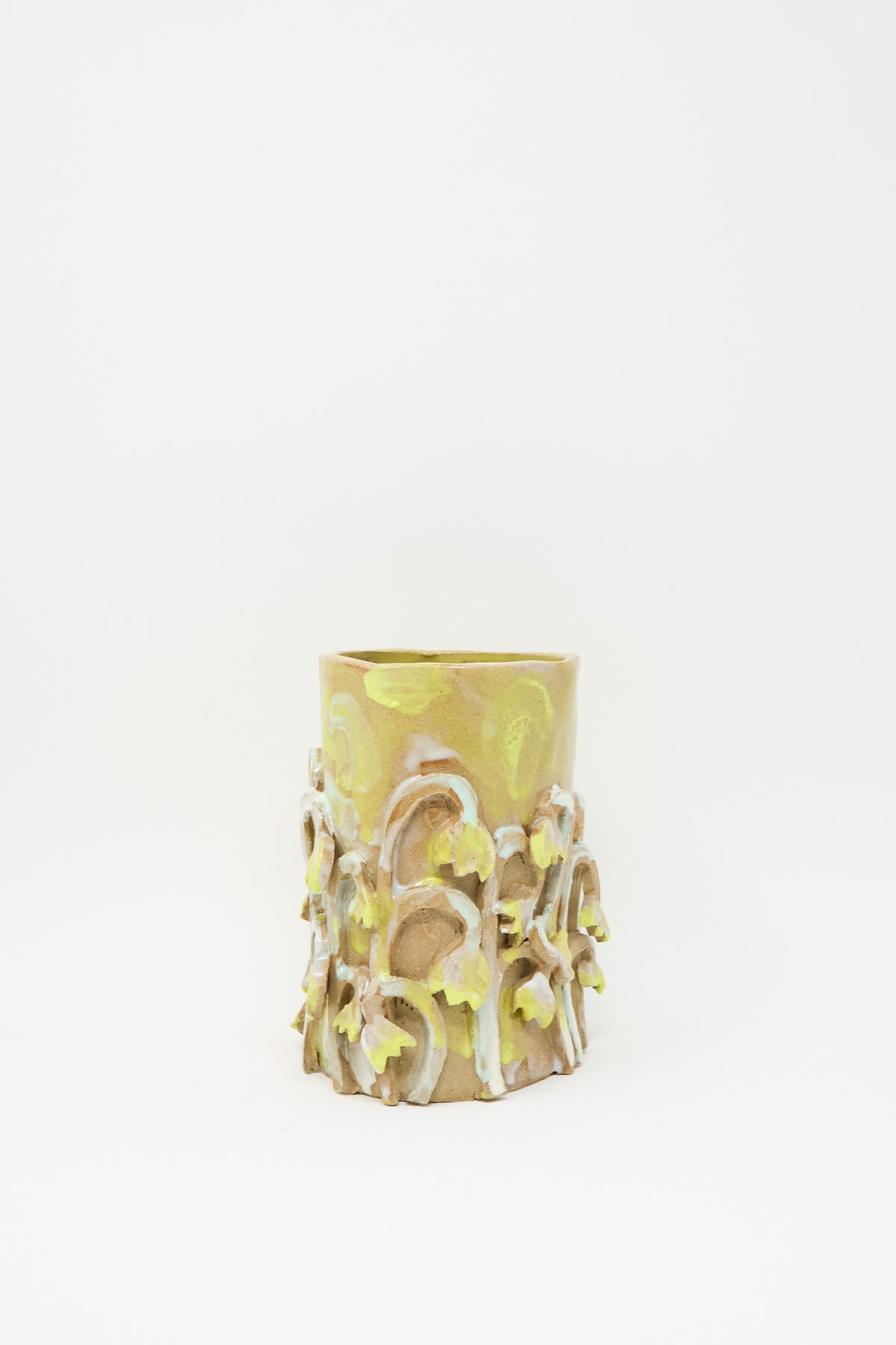 Tamar Mogendorff Yellow Fritillaria Vase, a handmade cylindrical ceramic piece decorated with raised, yellow-painted fritillaria flower embellishments.