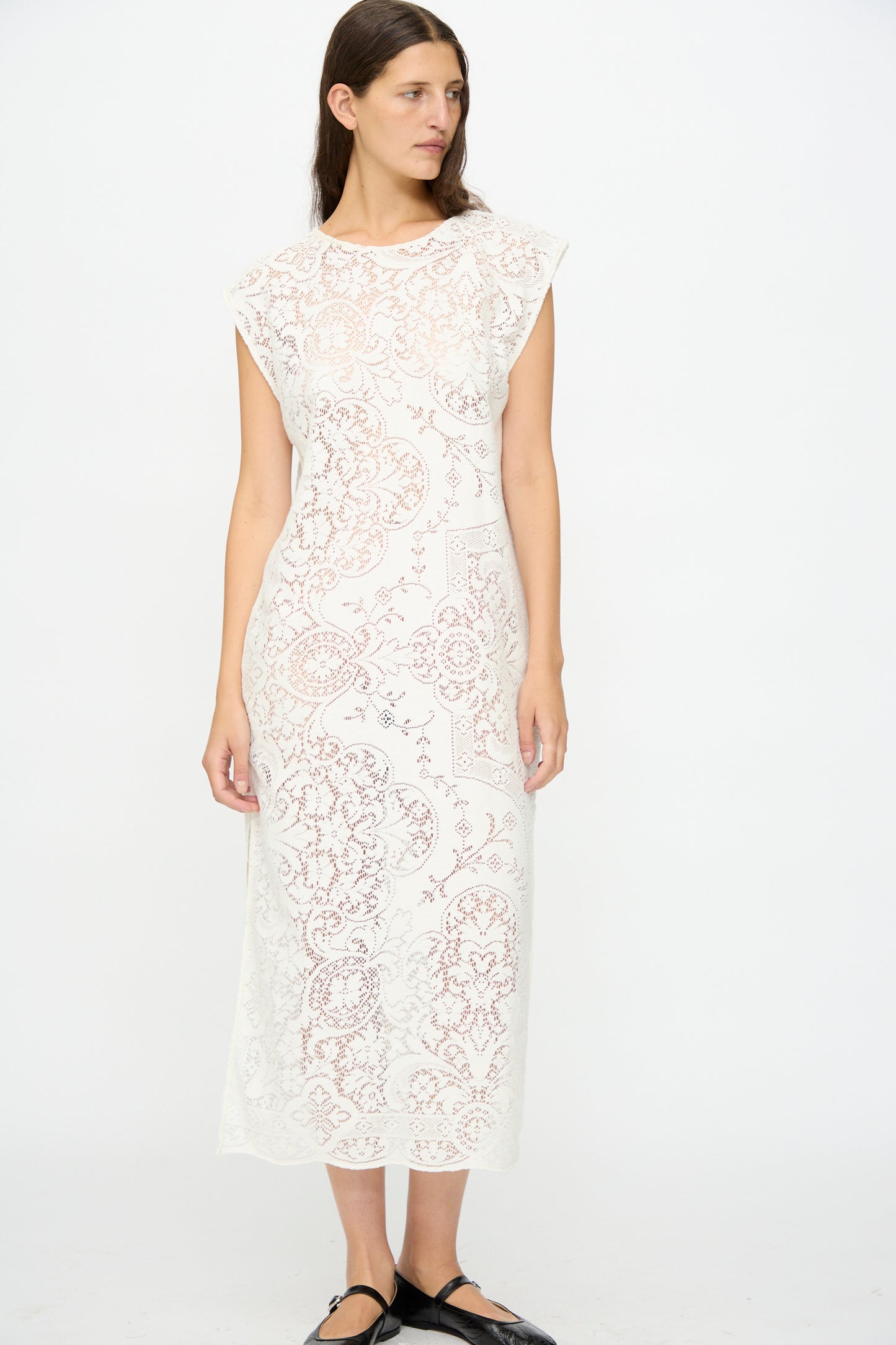 A woman models the Quaker Lace Caftan by Thank You Have A Good Day—a sleeveless, calf-length dress made in New York from antique Quaker lace, featuring intricate patterns and shown against a plain white background.