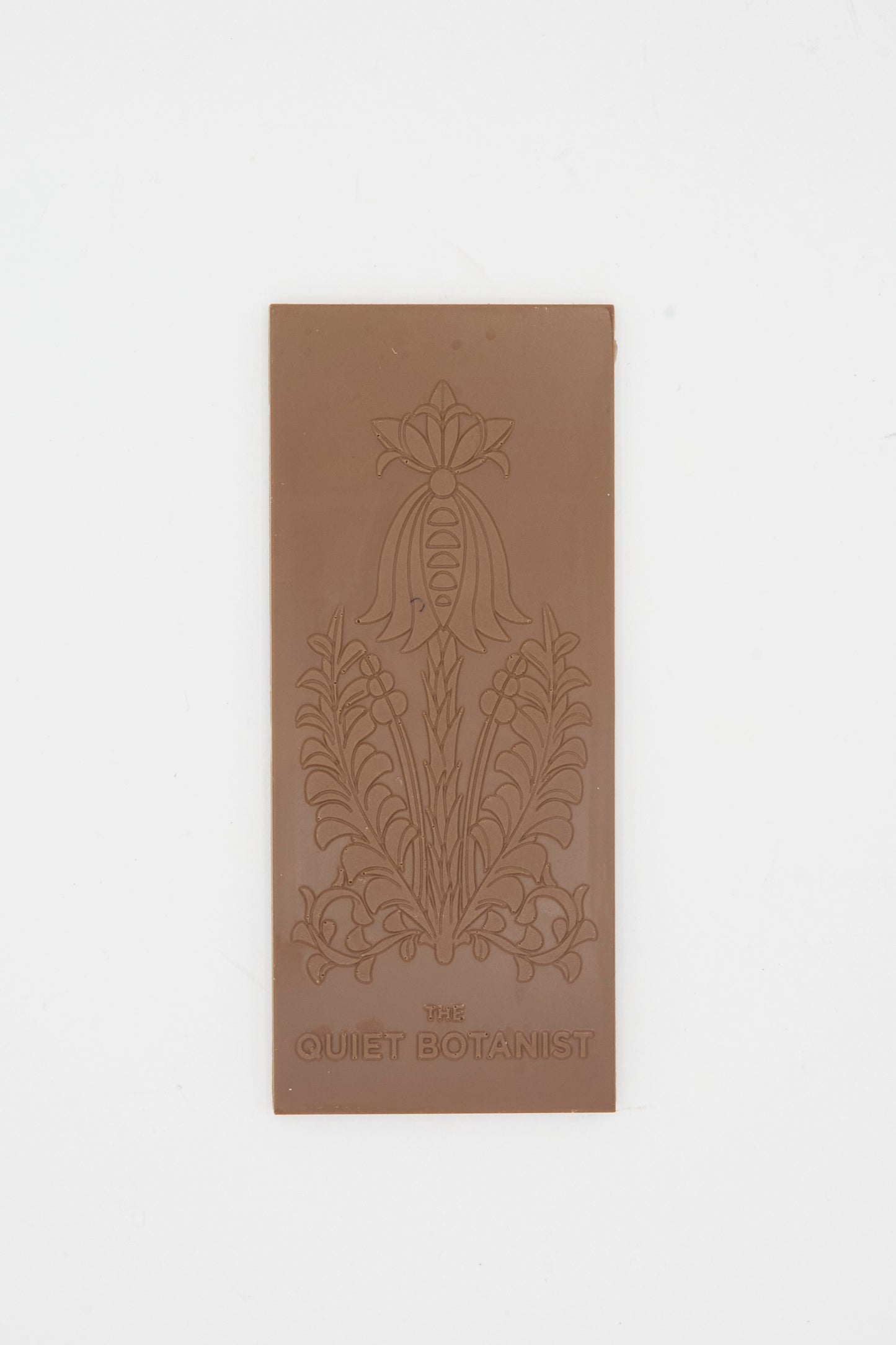 The Bunny Bar by The Quiet Botanist: a rectangular dark chocolate bar with an embossed floral design and "THE QUIET BOTANIST" near the bottom, subtly infused with blood orange, shown on a plain white background.