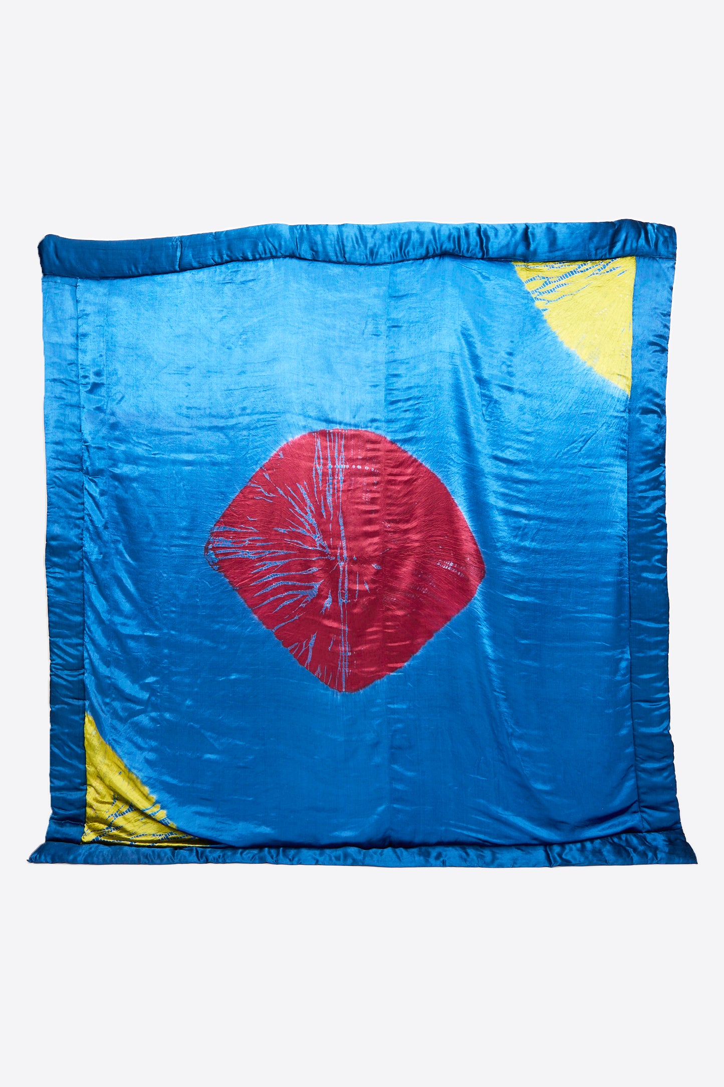 TIGRA TIGRA's Moon Dye Quilt in Jewel Blue features a luxurious sheen, magenta central diamond, and acid green corner accents. Expertly handcrafted in India.