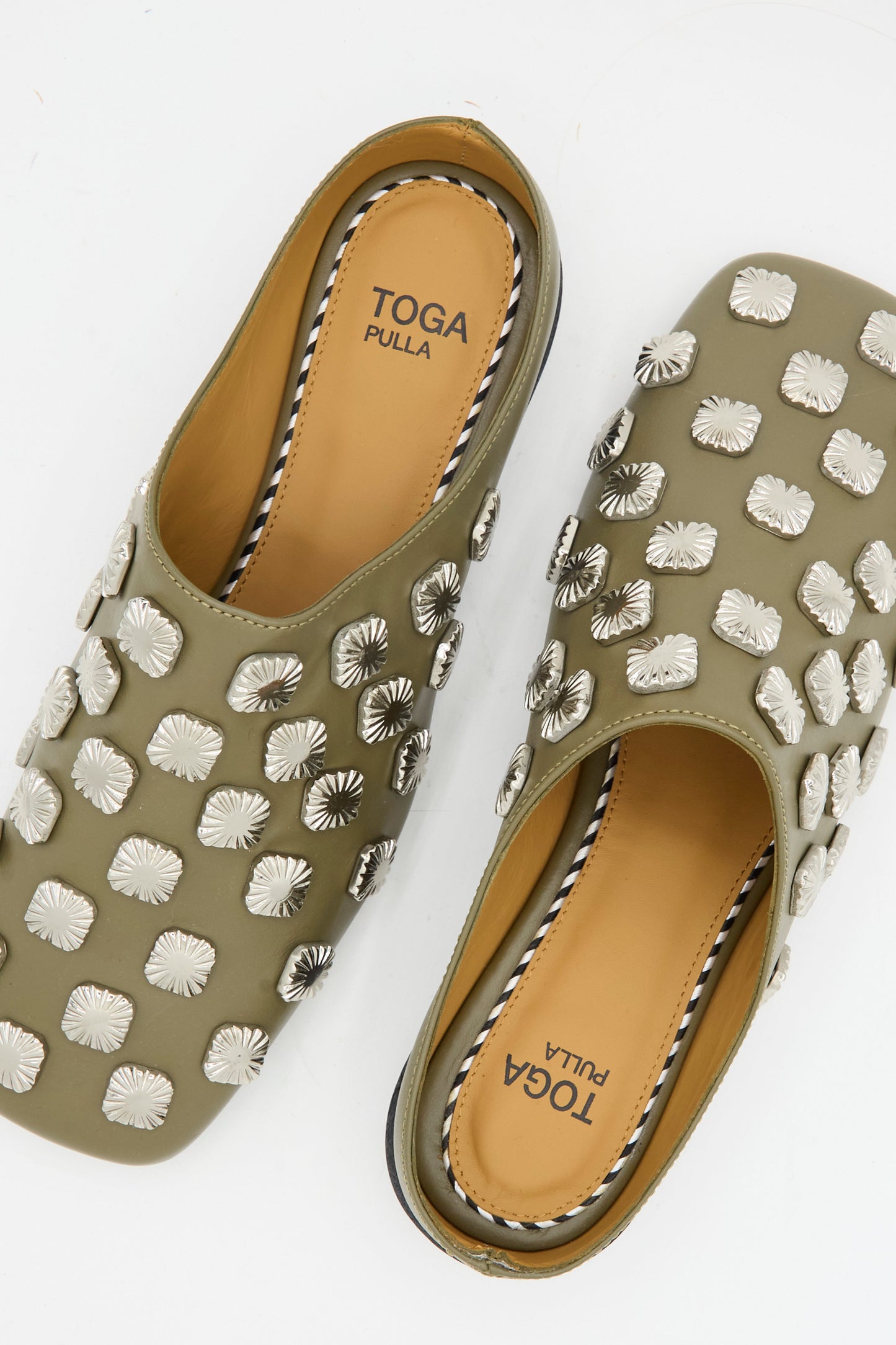 The Leather Mule in Khaki by TOGA ARCHIVES features silver square embellishments and tan insoles.