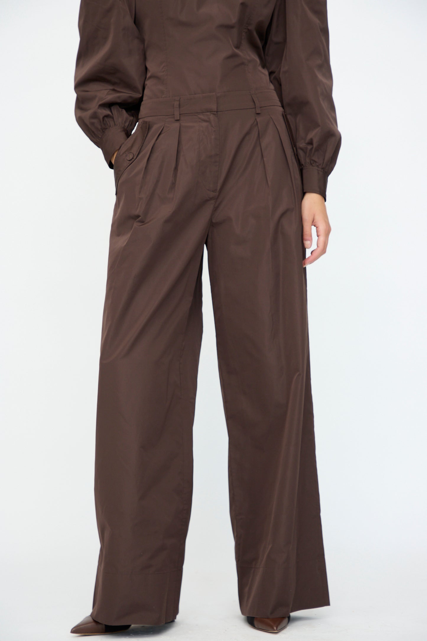 A person wearing the Ulla Johnson Charlie Silk Pant in Sequoia, paired with a matching long-sleeve top, stands against a plain white background.