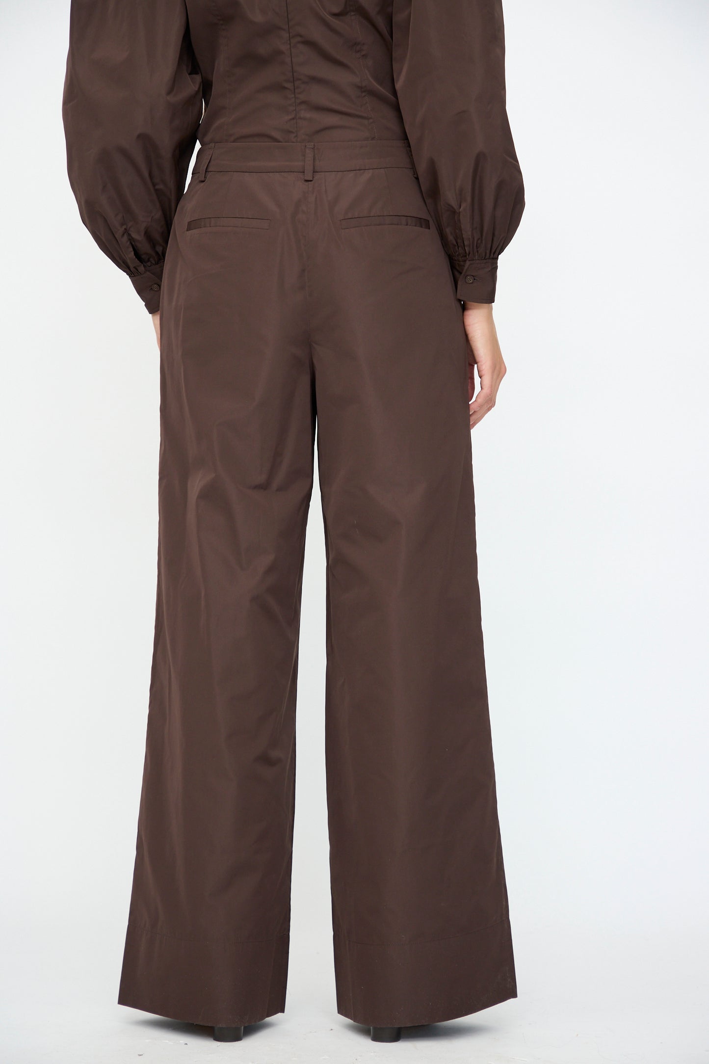Model shown from the back against a plain white background, wearing the Ulla Johnson Charlie Silk Pant in Sequoia paired with a matching brown top with puffy sleeves.