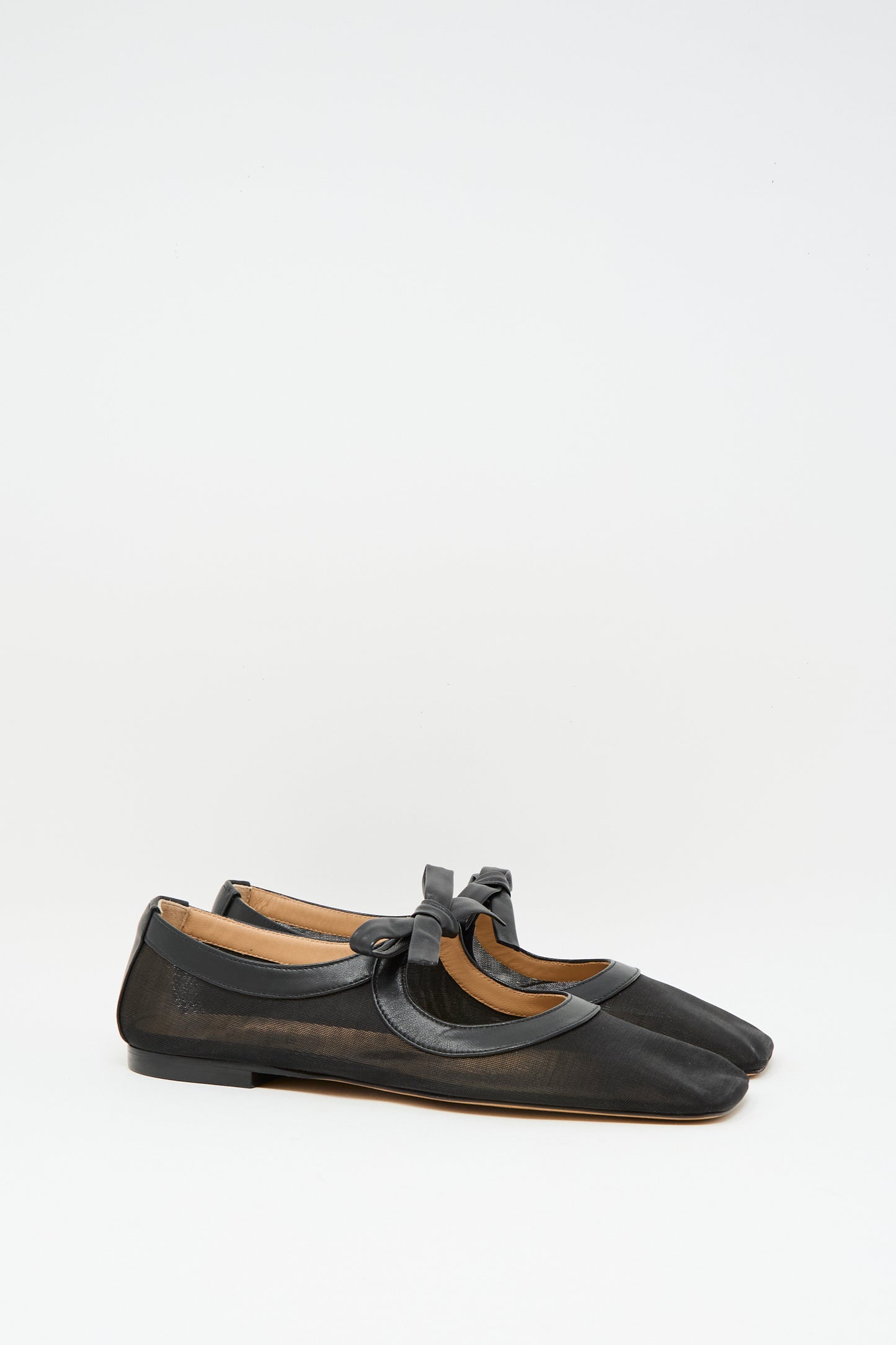 The Cleo Flat in Noir by Ulla Johnson, crafted from black napa leather with a bow detail and made in Italy, is displayed against a plain white background.