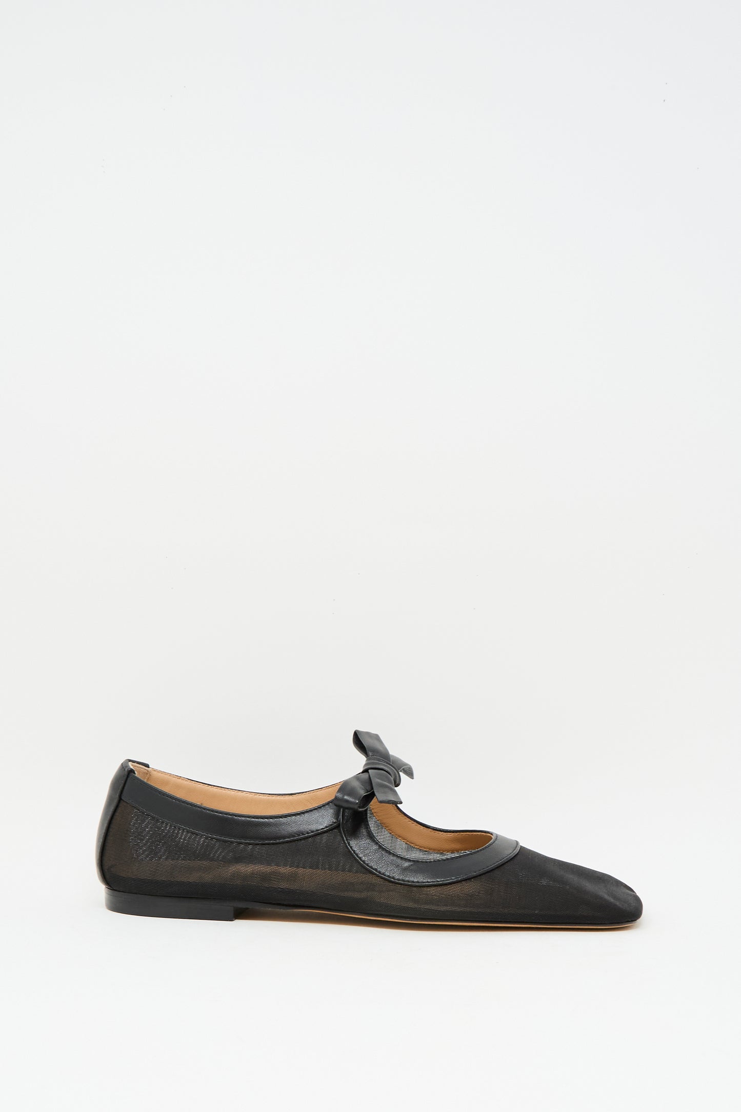 The Ulla Johnson Cleo Flat in Noir is a black napa leather ballet flat with a low heel, rounded toe, and bow-accented strap, made in Italy and shown on a plain white background.