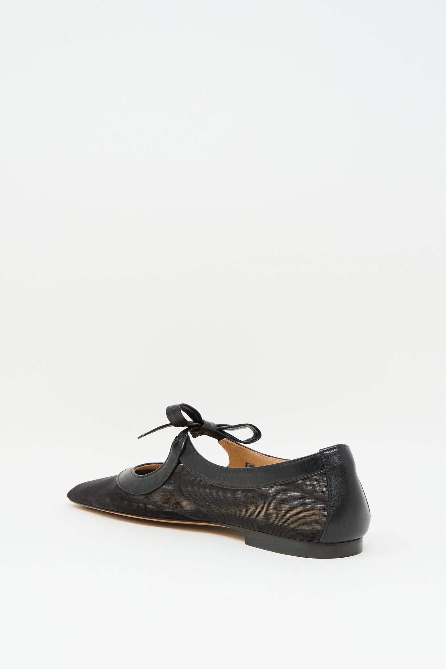 The Cleo Flat in Noir by Ulla Johnson is a black napa leather pointed-toe ballet flat with a bow and sheer mesh side panels, shown on a plain white background.
