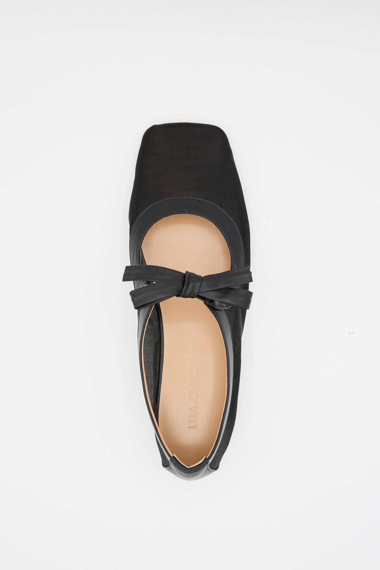 The Cleo Flat in Noir by Ulla Johnson is a black napa leather ballet flat with a square toe, front bow detail, and beige insole, shown from above on a white background.
