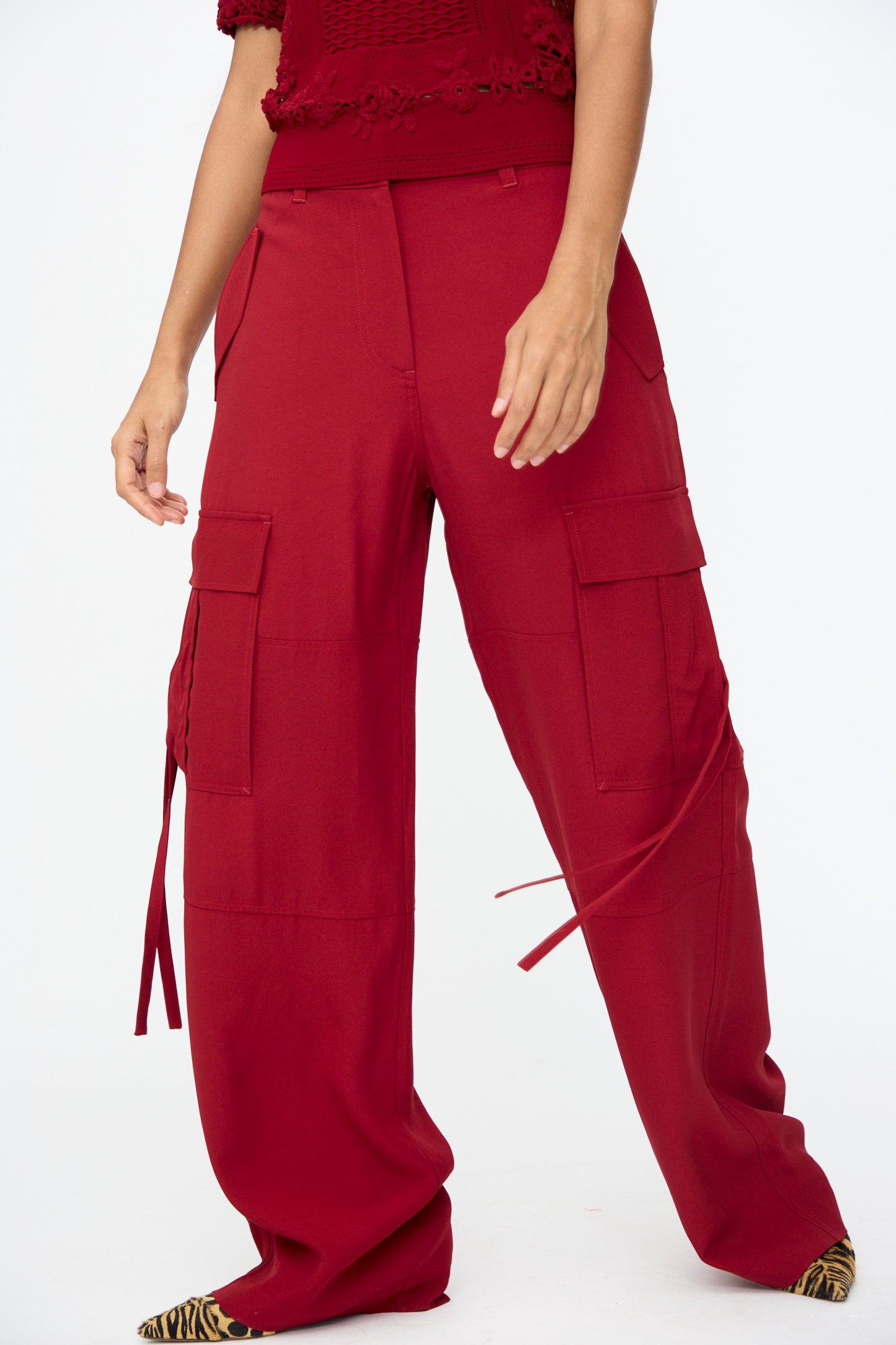 Only the lower body is visible, featuring the Pax Pant in Dahlia by Ulla Johnson—a relaxed fit, high-waisted red cargo pant with side pockets—paired with a matching red textured top.