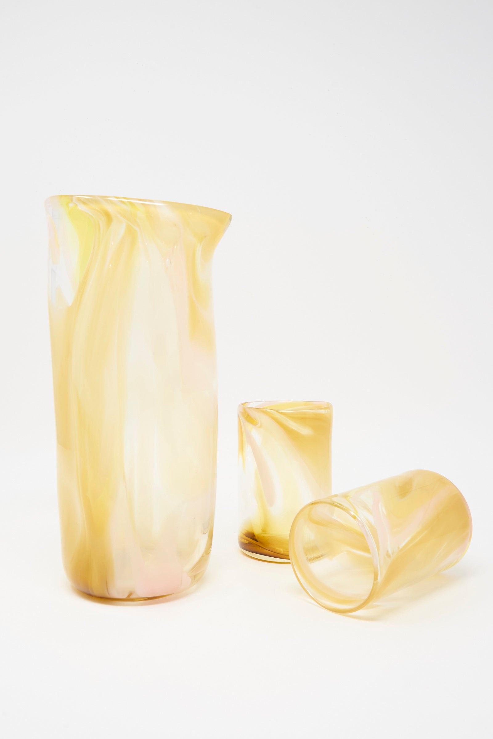 Upstate’s Hand Blown Carafe in Frankie—a translucent yellow glass carafe with two matching tumblers (one upright, one on its side)—is shown against a plain white background.