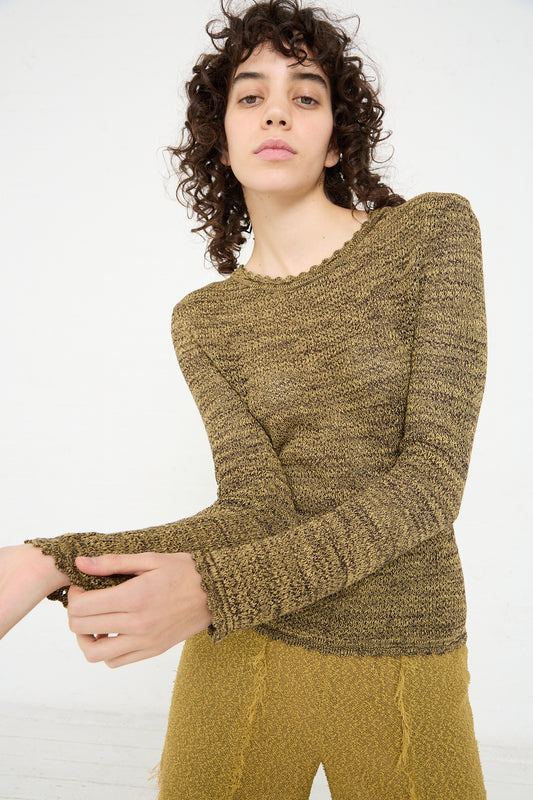 A woman wearing a yellow Veronique Leroy Long Sleeve Knit Top in Pepper and pants.
