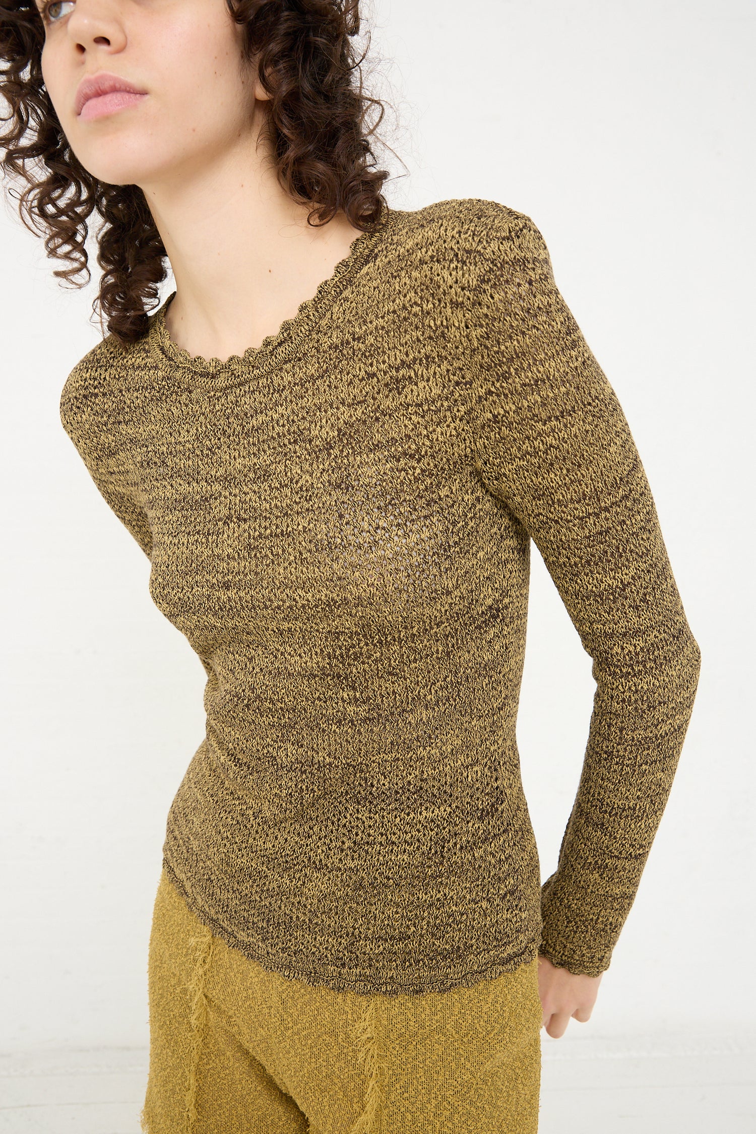 A woman in a yellow Long Sleeve Knit Top in Pepper by Veronique Leroy.