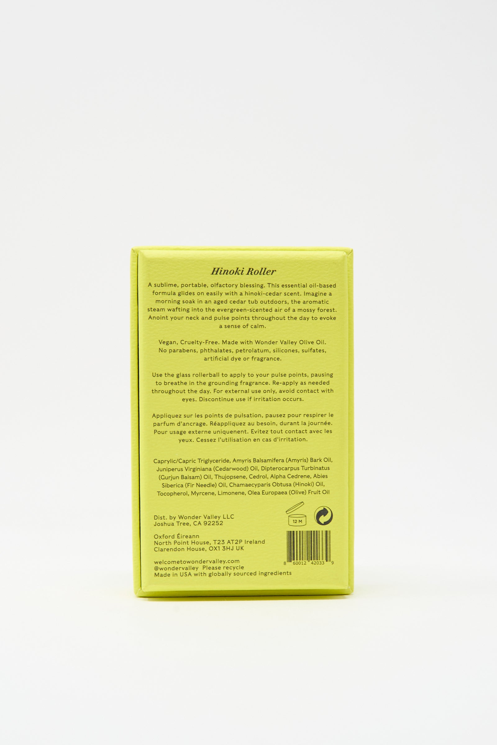 The upright yellow rectangular box displays product info, usage directions, ingredients, and company details—ideal packaging for your Wonder Valley Hinoki Roller, a portable hinoki cedar scent or essential oil-based perfume.