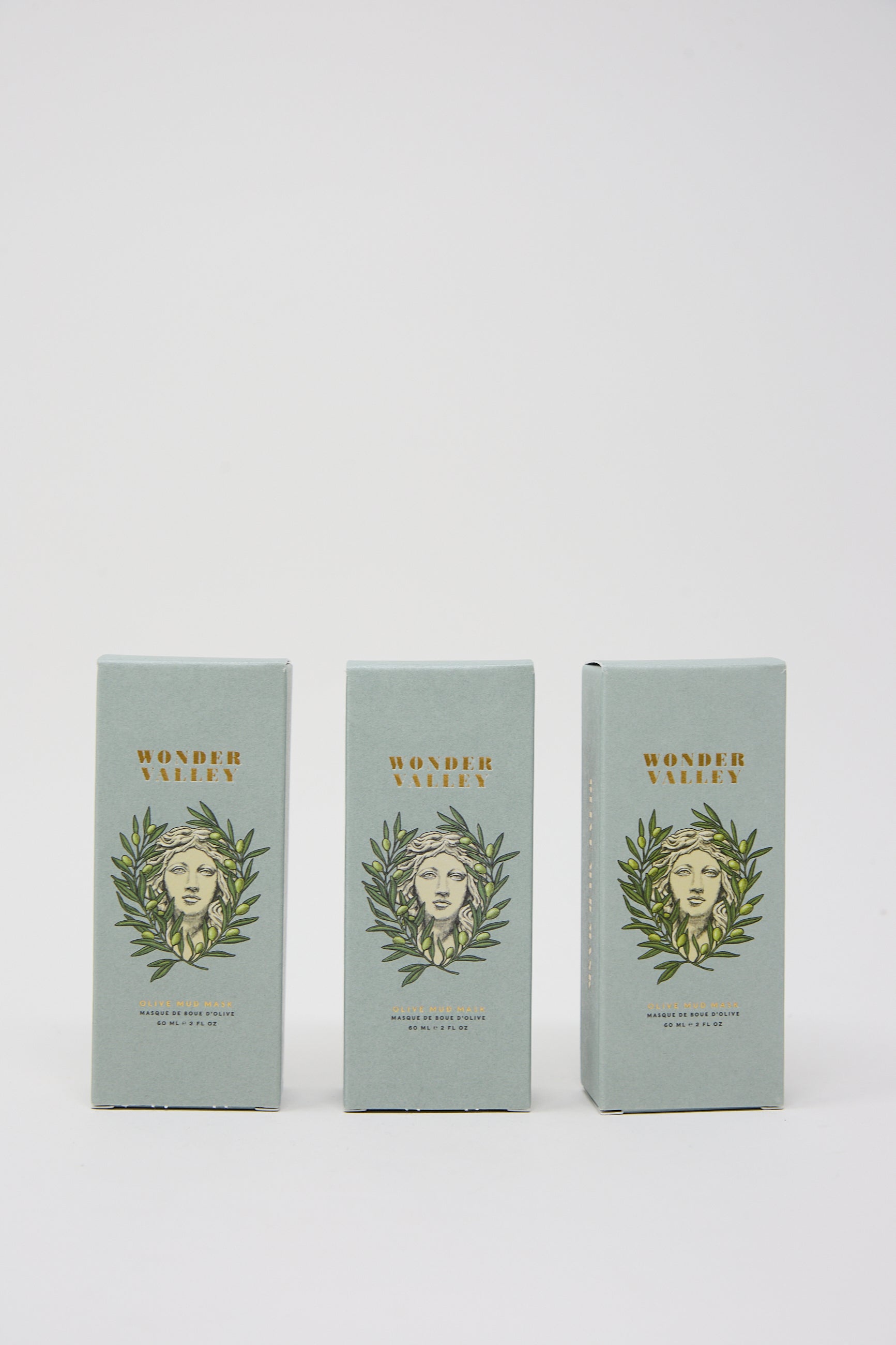 Three boxes labeled "Wonder Valley Olive Mud Mask" with the illustration of a woman's face surrounded by leaves on a white background.