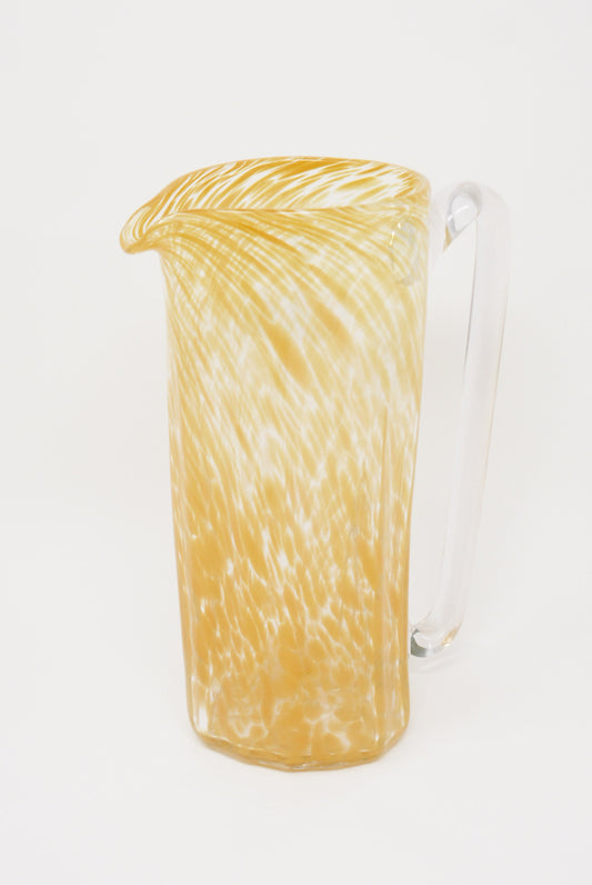 A Large Saffron Recycled Glass Pitcher from Xaquixe with a clear handle against a white background.