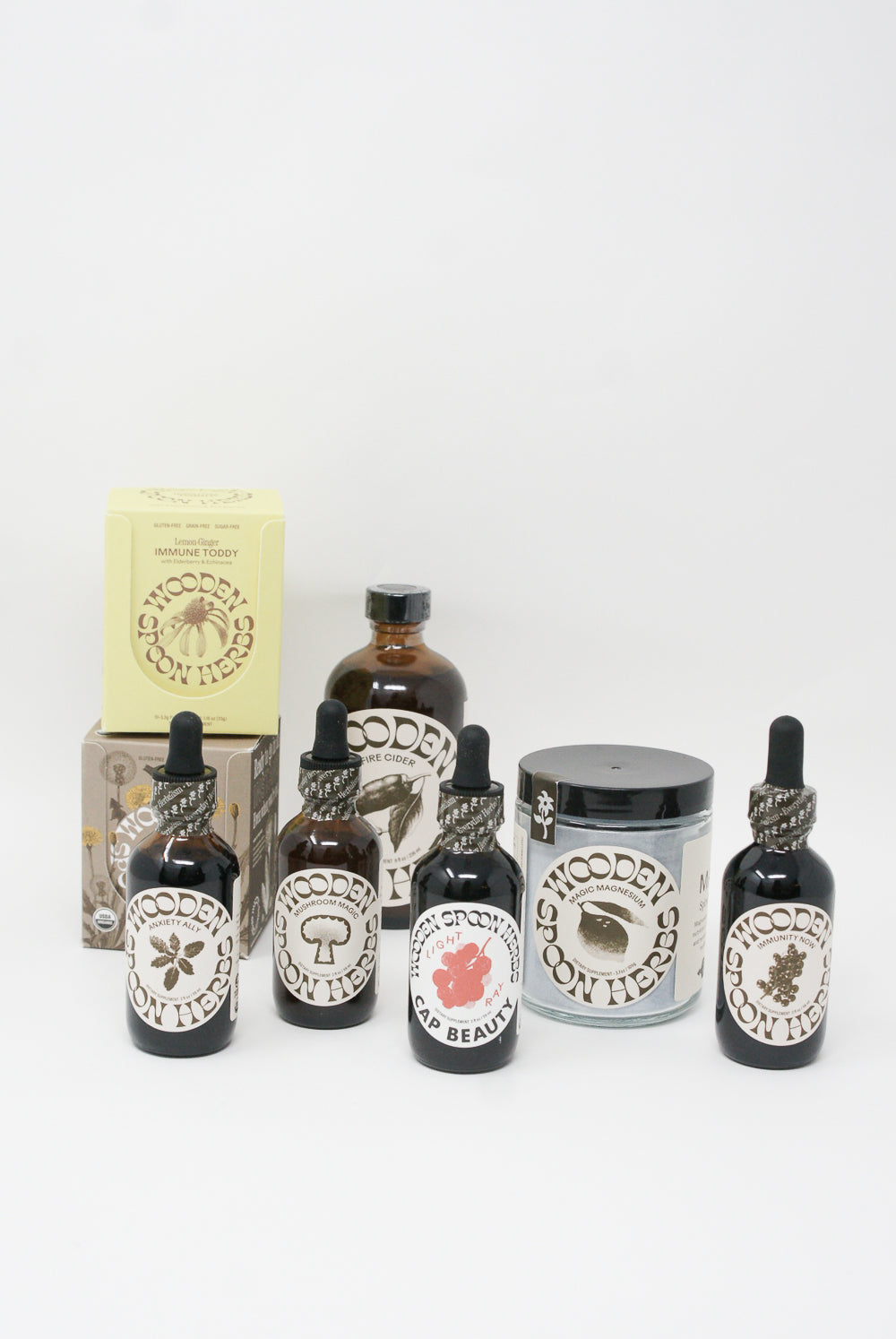 A collection of Anxiety Ally Tincture grooming products with labels, including oils and balms, infused with USDA Organic herbal extract by Wooden Spoon Herbs.