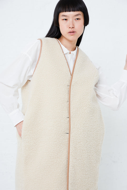 The model is wearing a Toujours Silk Gabardine Reversible Padded Liner Long Vest in Sand with a front button closure.