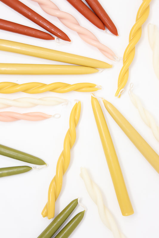 Assorted twist Beeswax Dining Candles in Natural colors arranged on a white background by Wax Atelier.