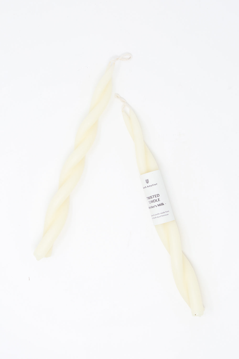 Two Hand Twisted Beeswax Candles in Mother's Milk by Wax Atelier on a white background.
