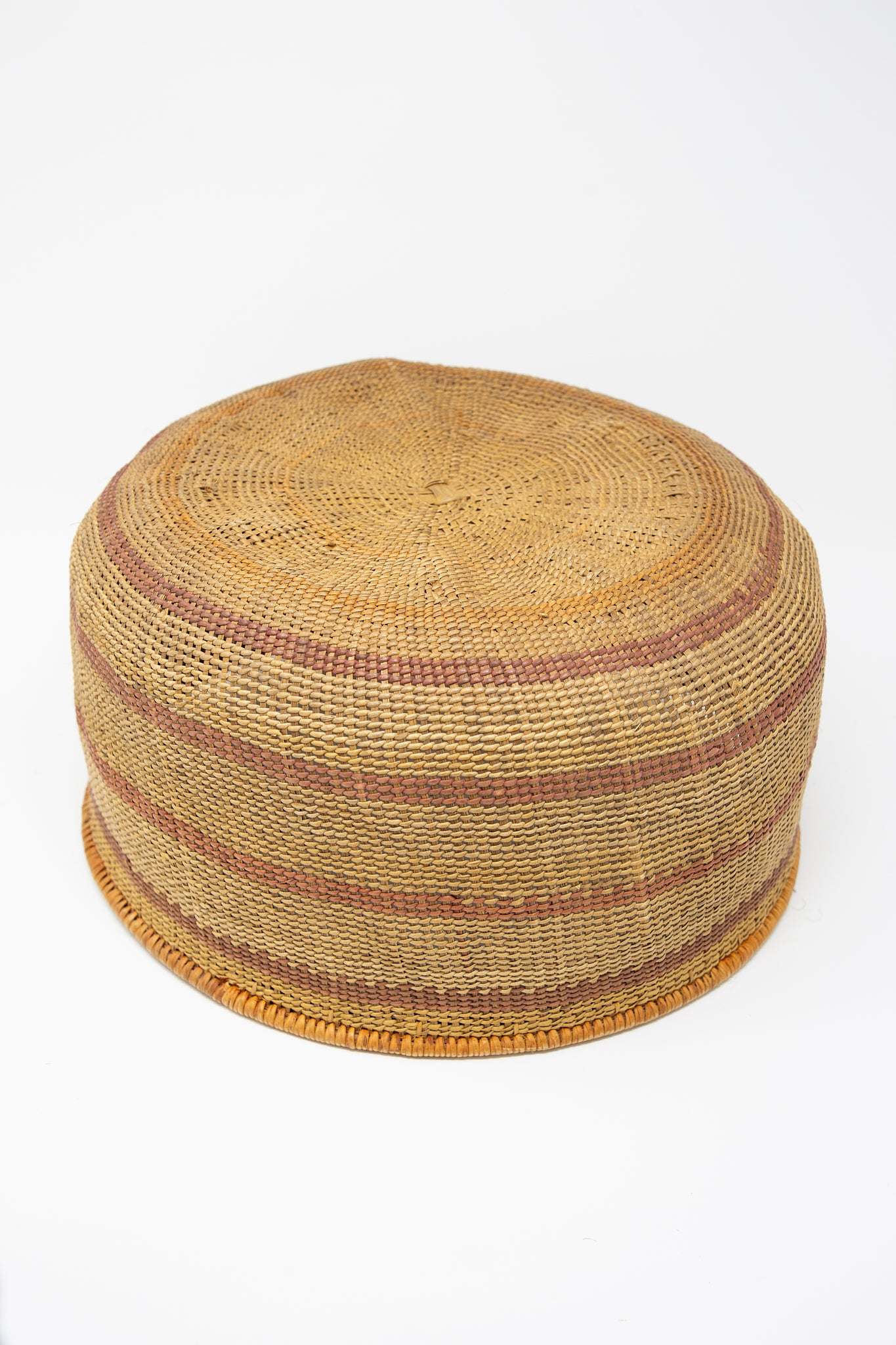 An XL Nukak Makú Basket woven using traditional basket weaving techniques on a white background, by Plaza Bolivar. Up side down view.