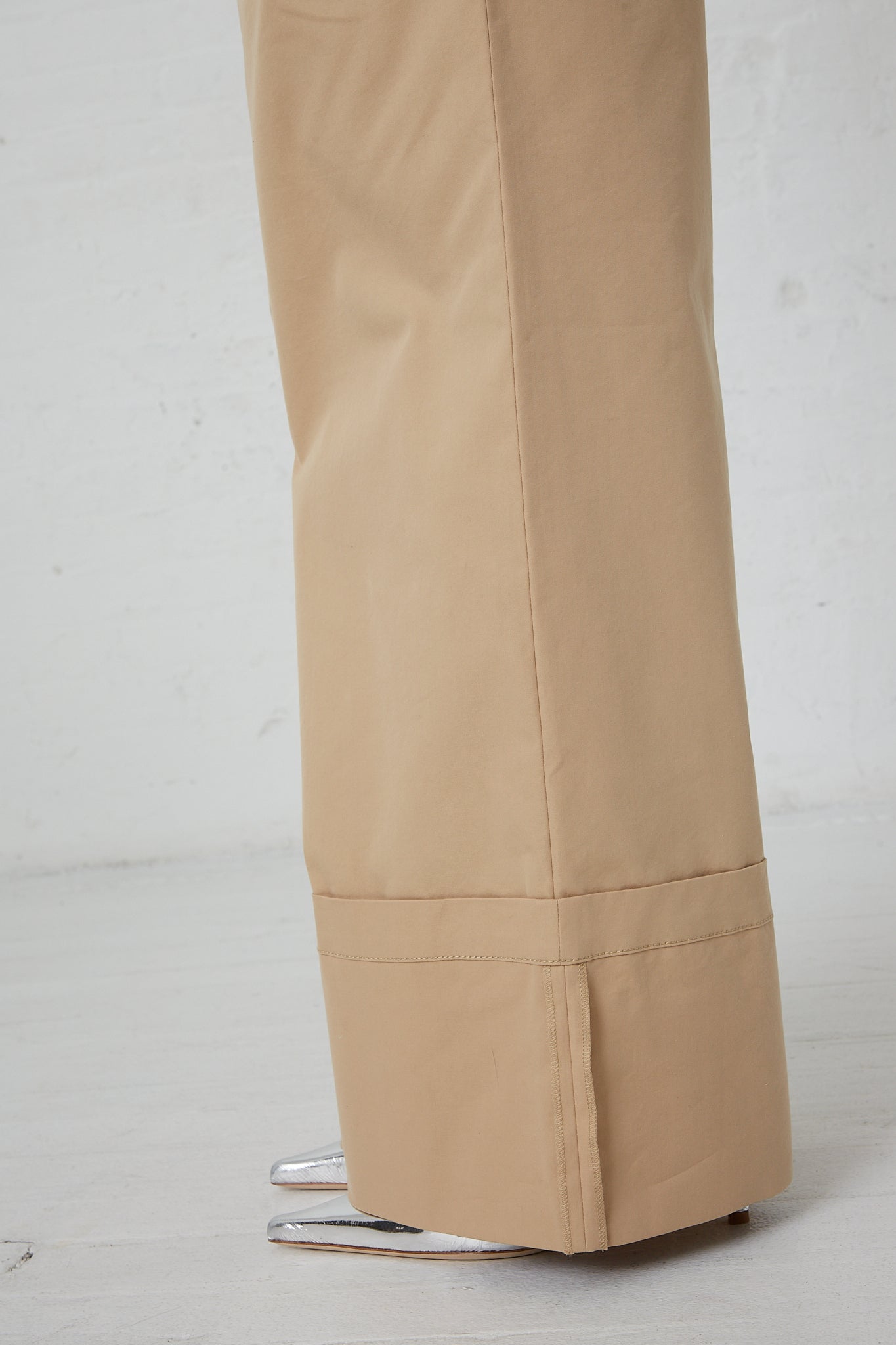 A woman wearing a pair of Rejina Pyo Cotton Blend Macie Trouser in Tan. Side view of the bottom of the pant. Up close.
