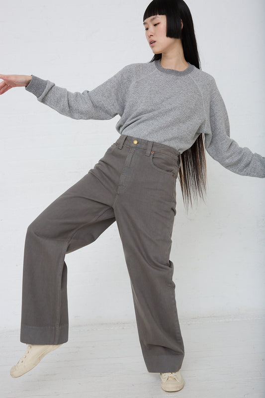 A woman wearing B Sides Easy Mid Relaxed Jean in Olive Overdye wide leg pants. Front view.