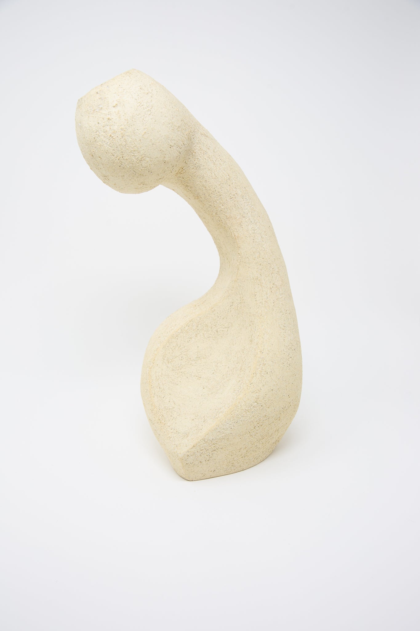 Abstract stone sculpture with a curved form crafted from Lost Quarry's Large Hand Built Vessel No. 000711 Bud Vase on a white background.