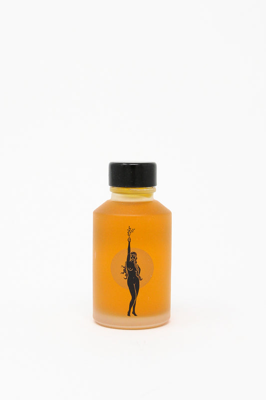 A revitalizing bottle of Wonder Valley Face Oil showcasing a woman's image - perfect for hydrating and reviving all skin types.