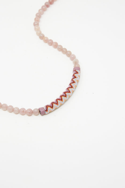 A handmade pink and white Beaded Bar Necklace in Madagascar Rose Quartz, by Robin Mollicone, displayed on a white surface.