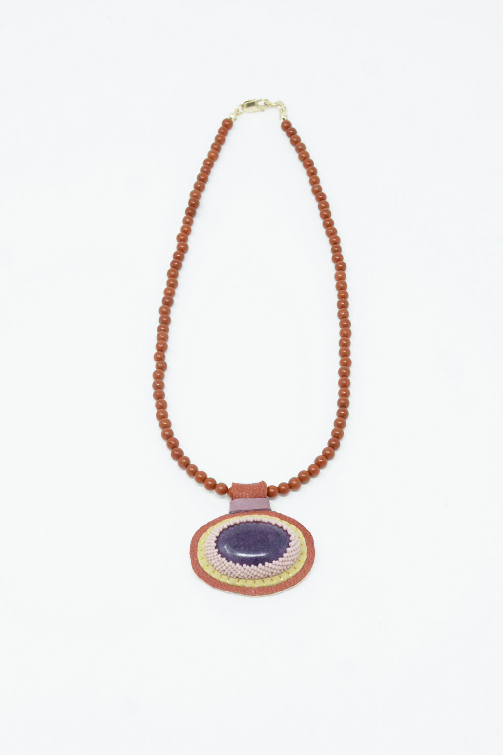 A Robin Mollicone Charm Necklace in Red Jasper Beads and Purpurite Charm adorned with a wooden bead.