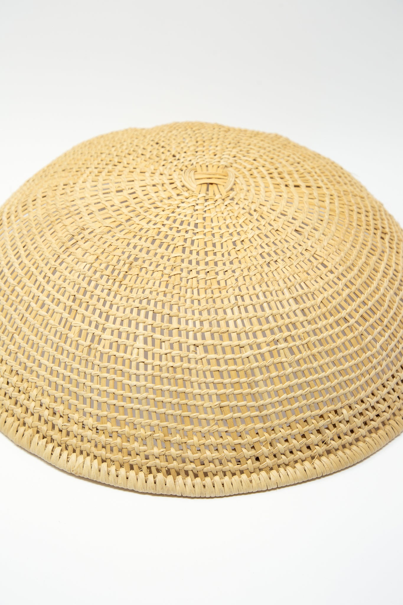 An artisan-crafted Large Avia Pova Basket by Plaza Bolivar on a white background showcasing intricate weaving techniques. Upside down.