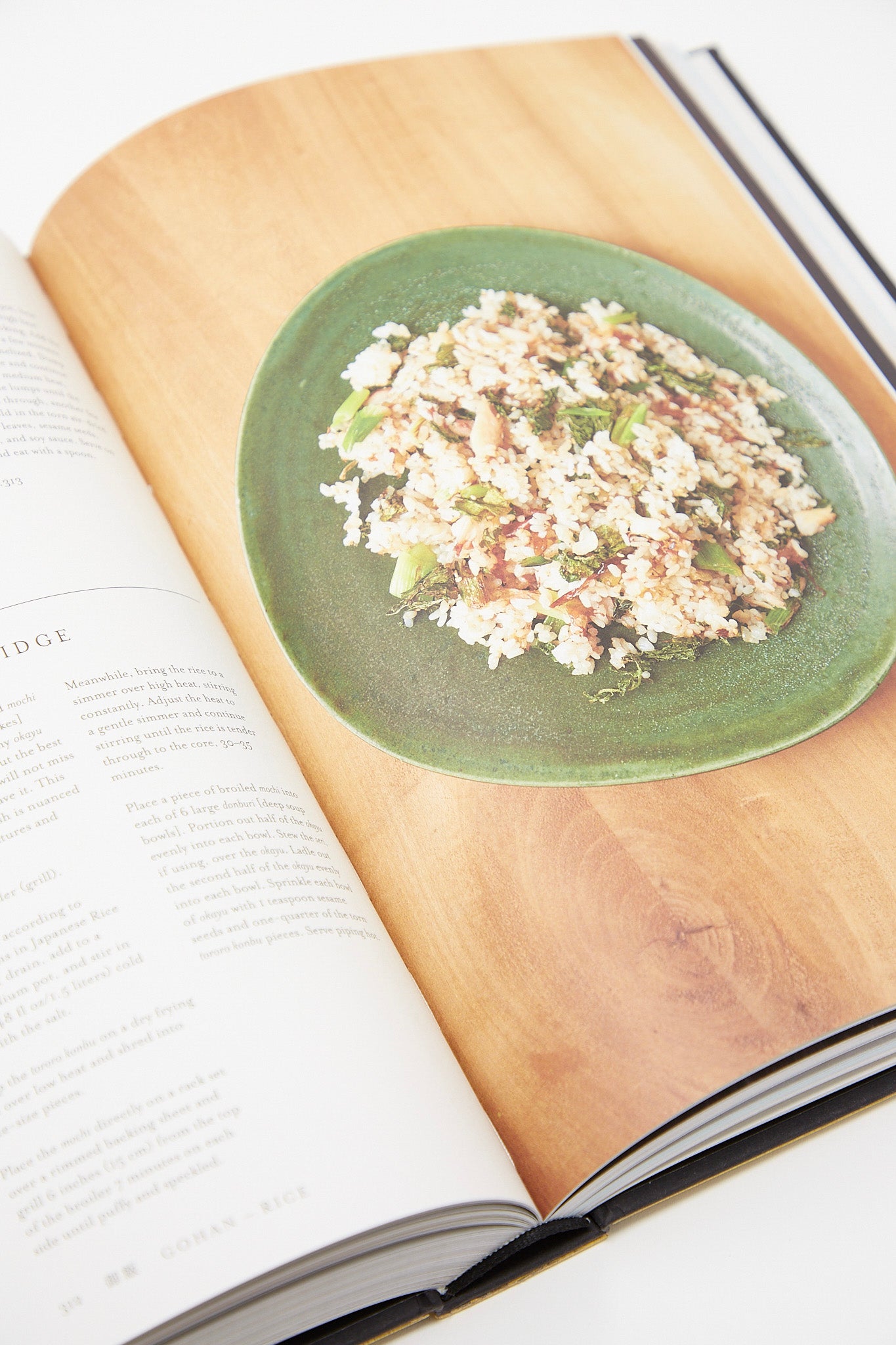 An author's open book with a plate of food on it, showcasing delightful recipes from the Phaidon - Nancy Singleton Hachisu Japan Cookbook.