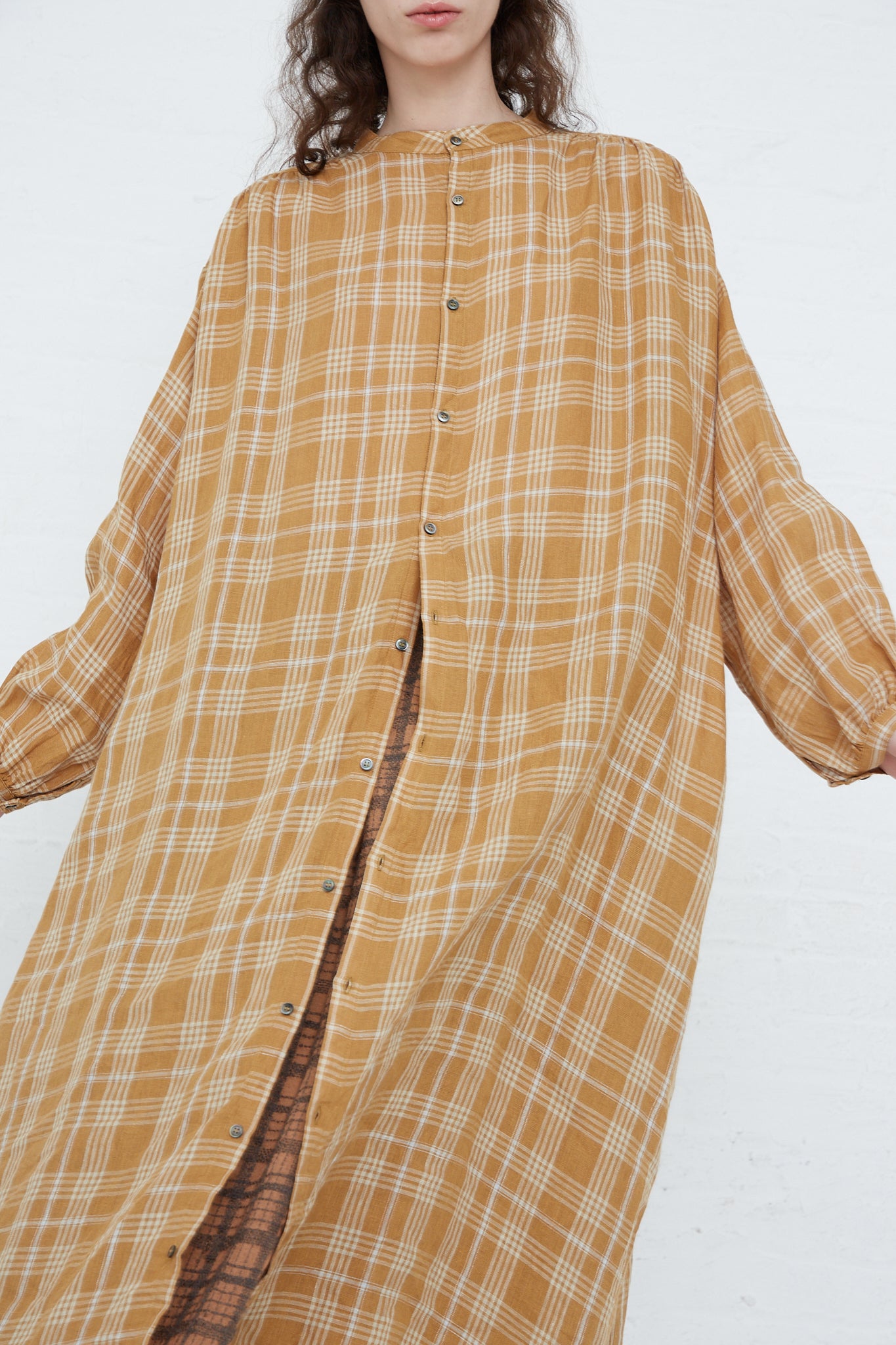 The model is wearing a Linen Check Dress in Camel from Ichi Antiquités.