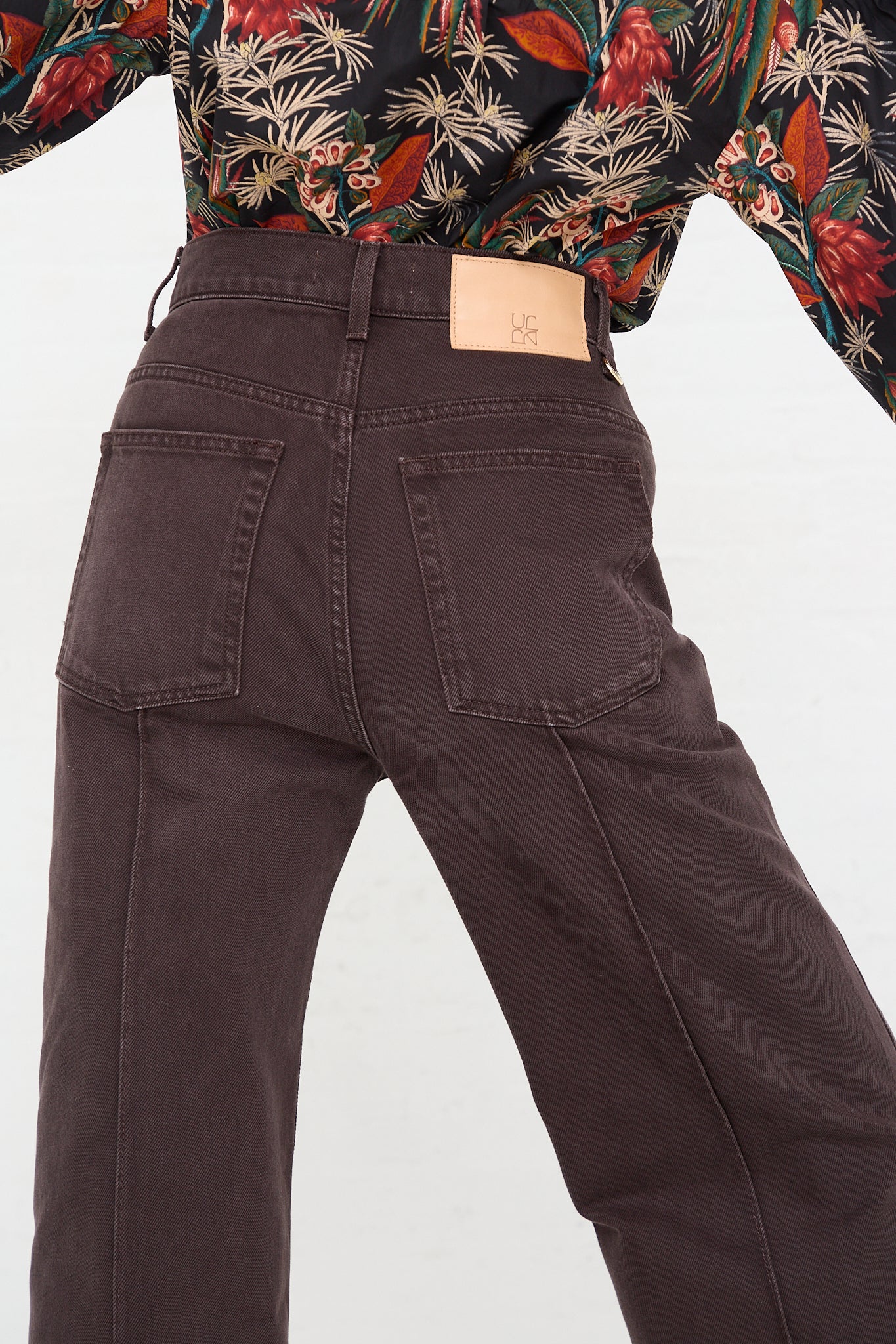 A woman in a floral shirt is wearing a pair of Ulla Johnson's Genevieve Jean in Mahogany Wash.