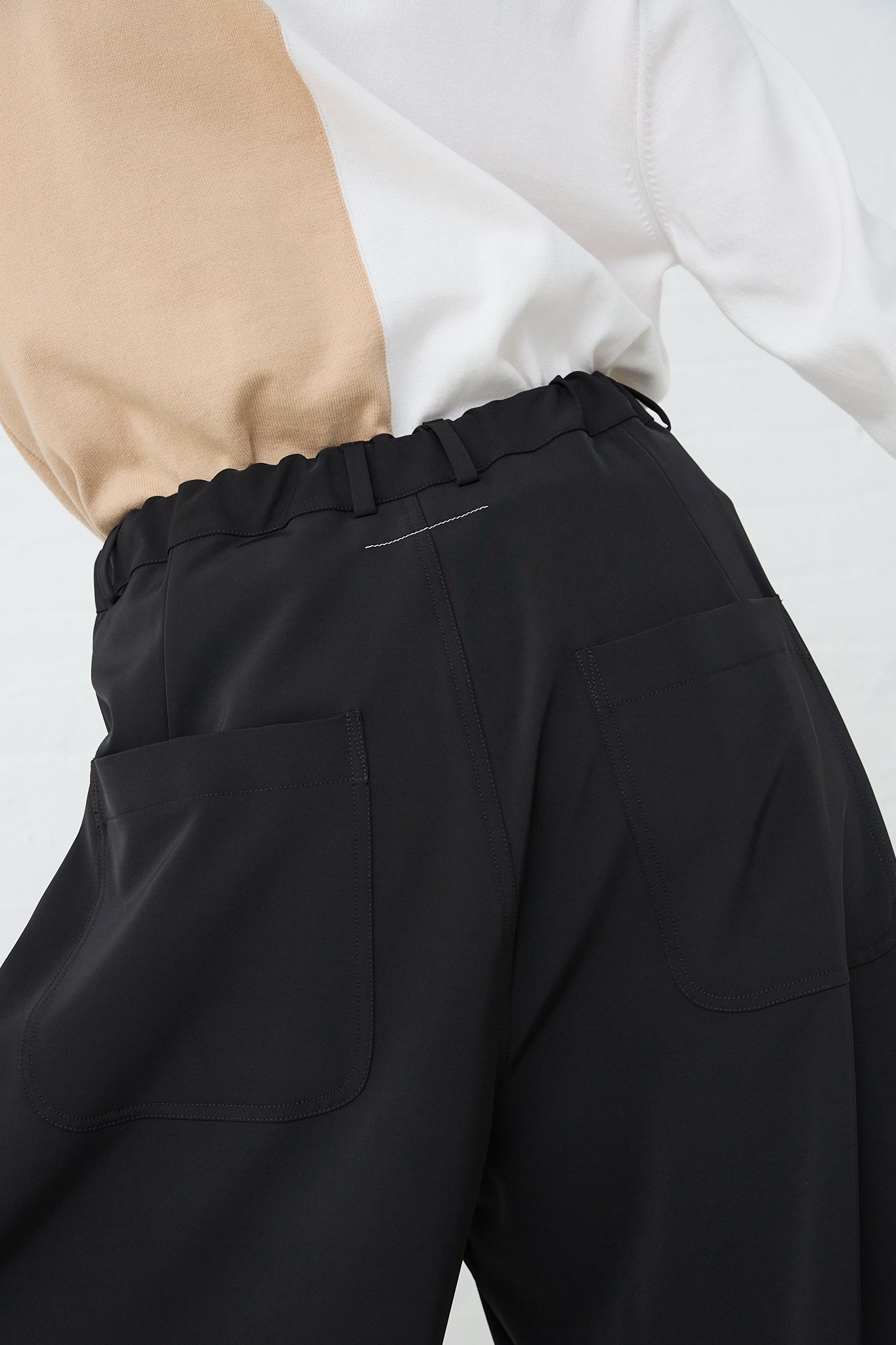 A model wearing MM6's Pant in Black. Back view and up close of pockets.