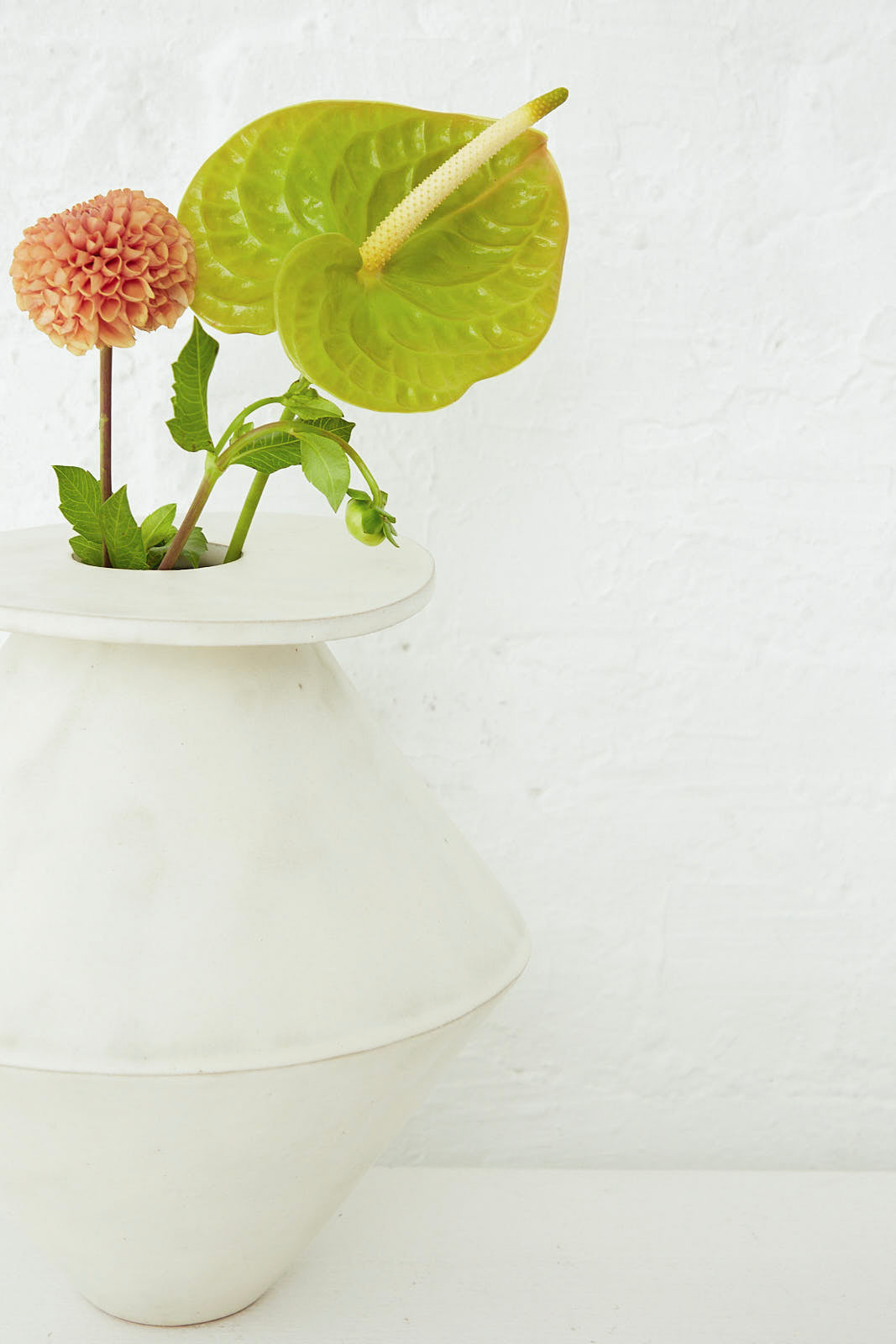 A BZIPPY Jumbo Diamond Vase in Cream with a flower in it.