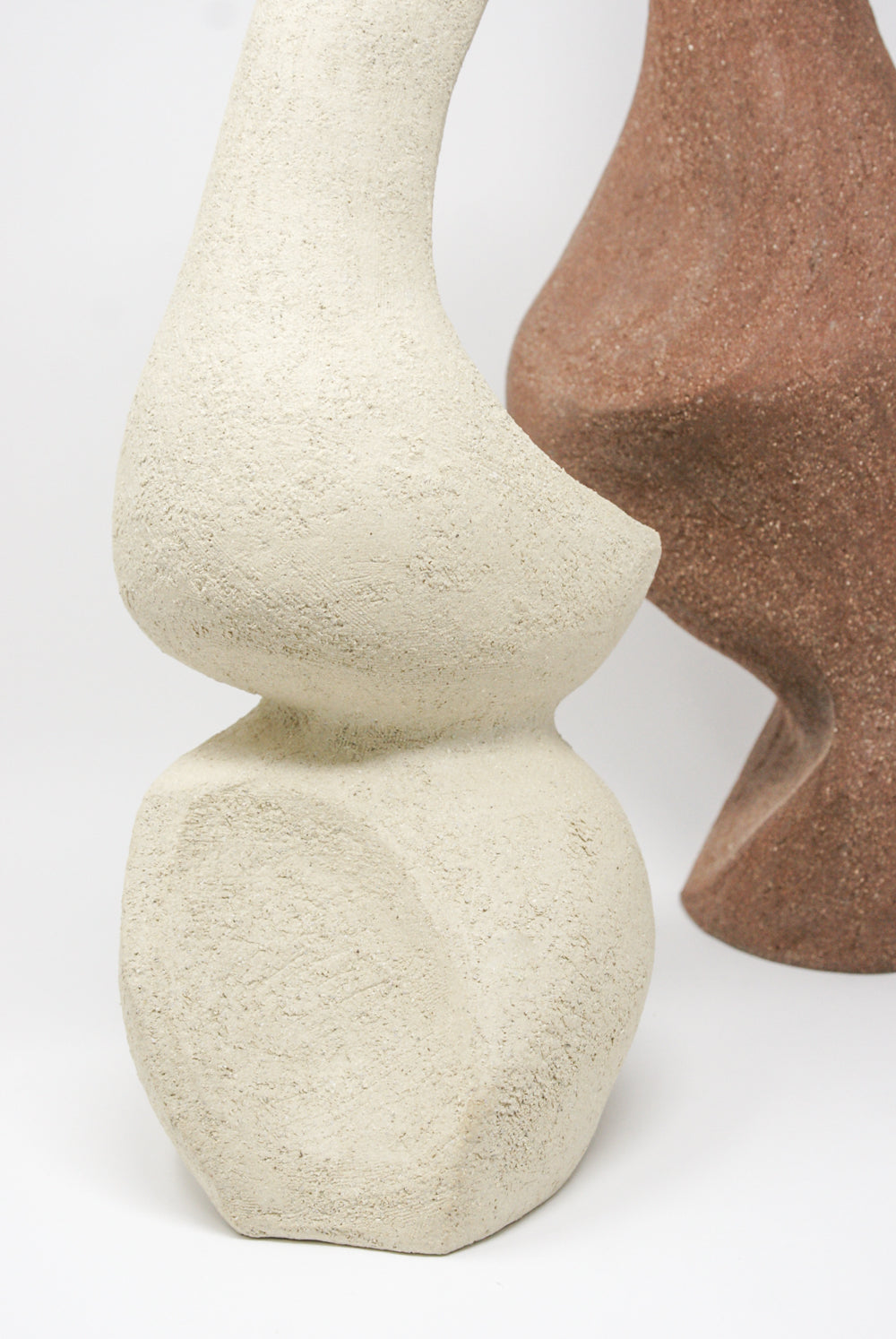 Hand Built Vessel No. 000345 by Lost Quarry, featuring beige and brown abstract designs with textured surfaces, positioned next to each other on a white background.