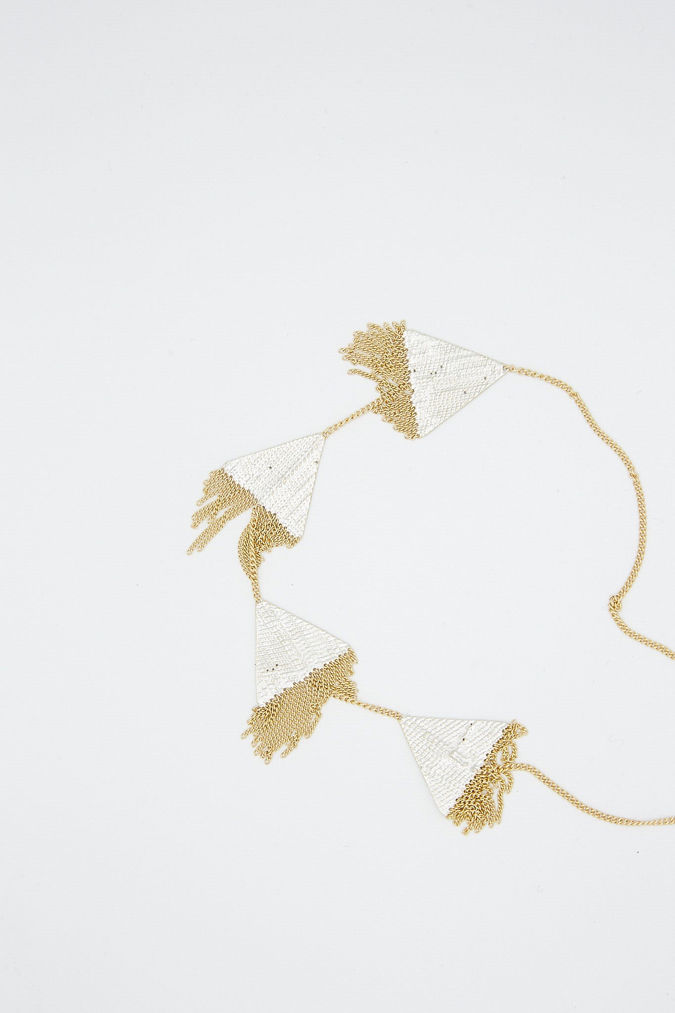 A Hannah Keefe Triangle Necklace in Brass Chain and Silver Solder with geometric forms and tassels.